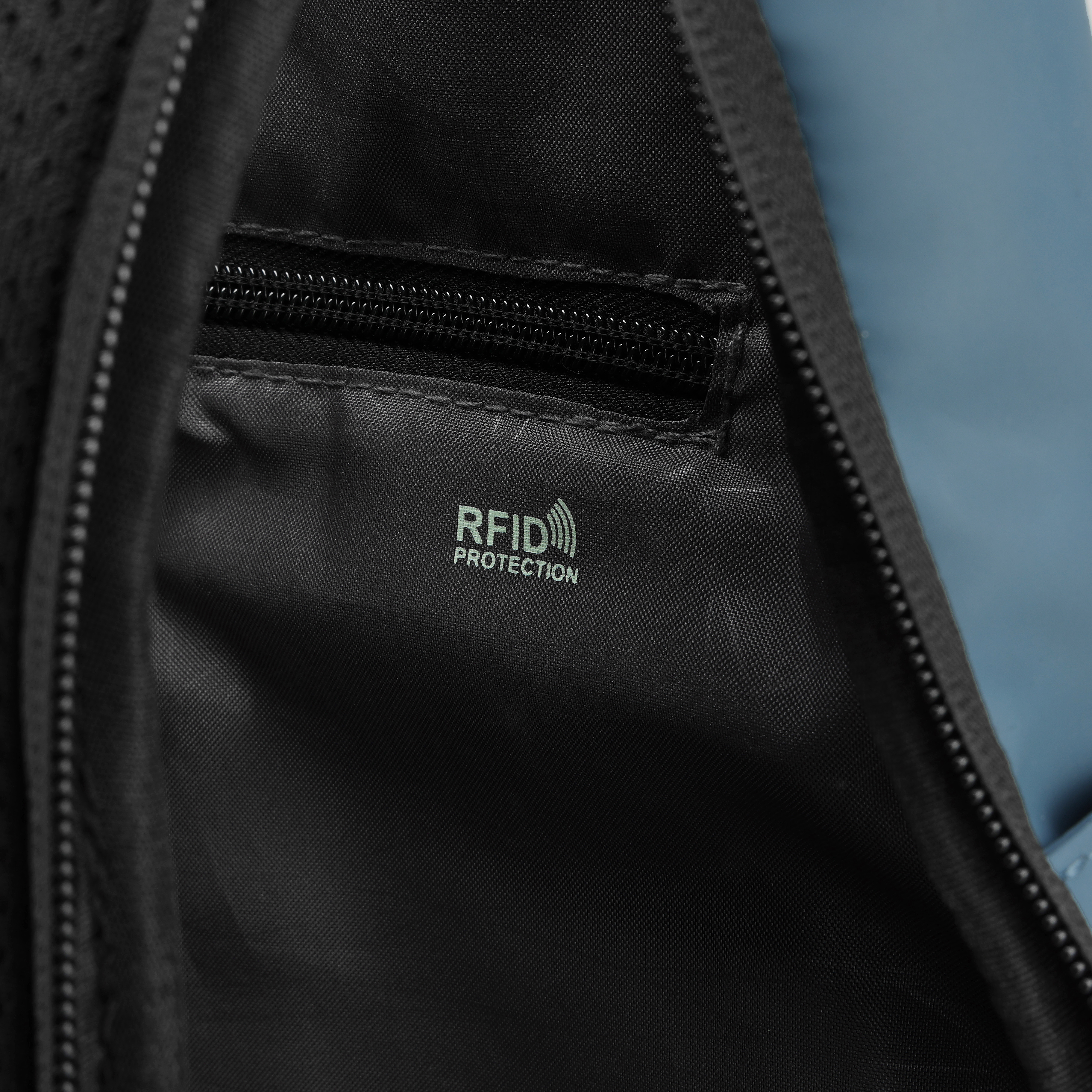All'interno di una borsa nera. Ha una cerniera, un'etichetta di protezione RFID e materiale blu.