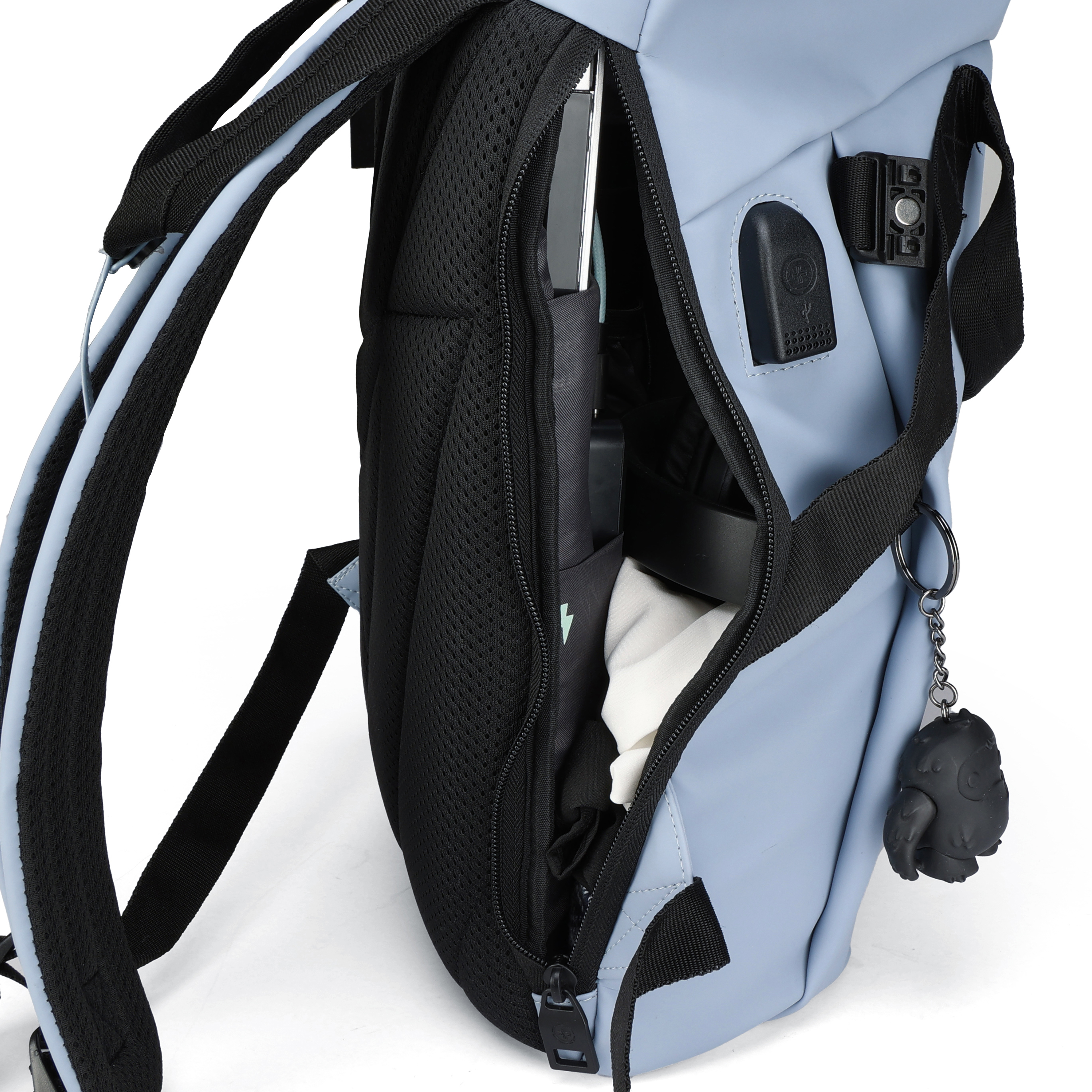 Uno zaino azzurro con cinghie nere. Lo scomparto aperto rivela un laptop, vestiti e un accessorio nero.