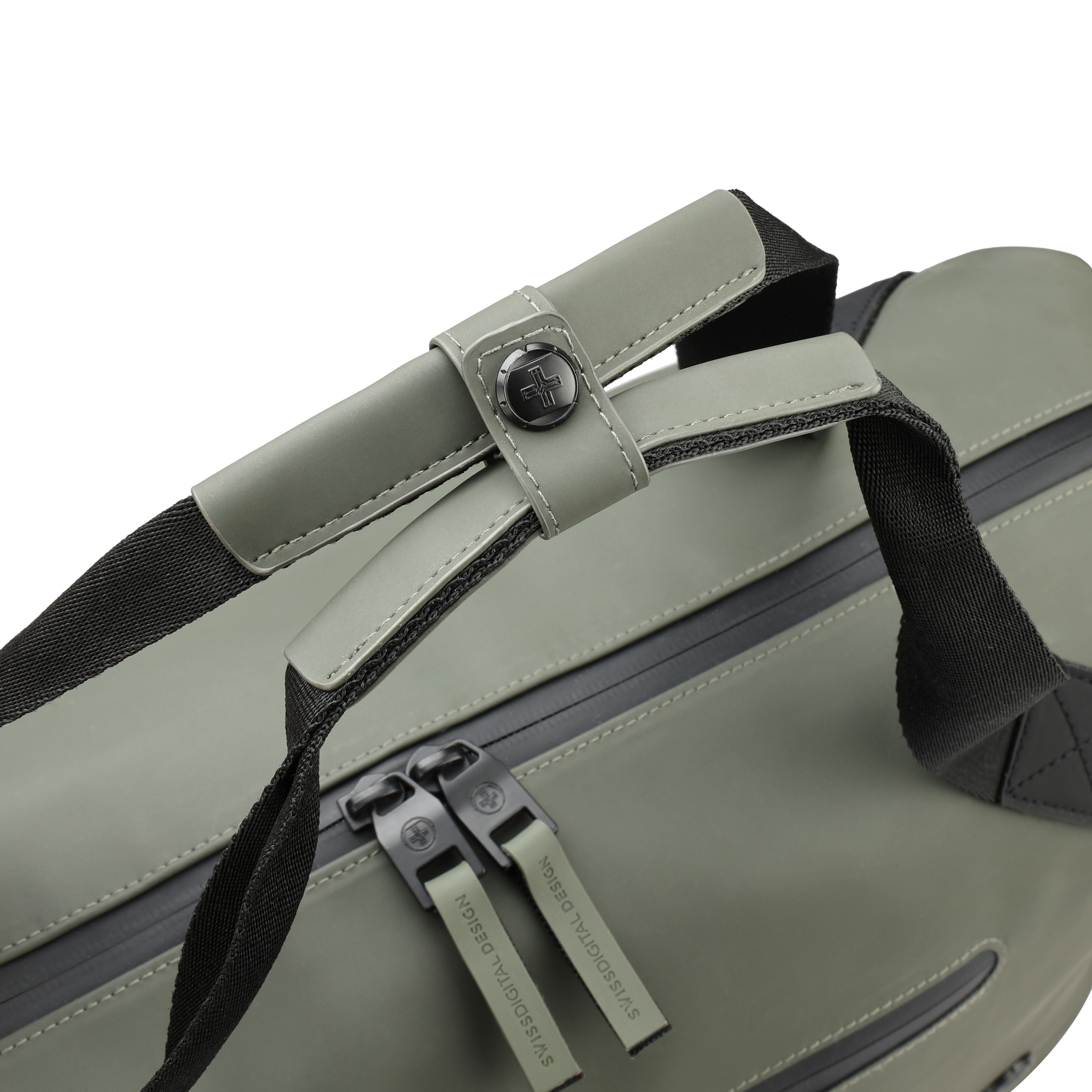 Primo piano di una borsa verde con cinghie e cerniere nere. La borsa ha un manico con un bottone nero.