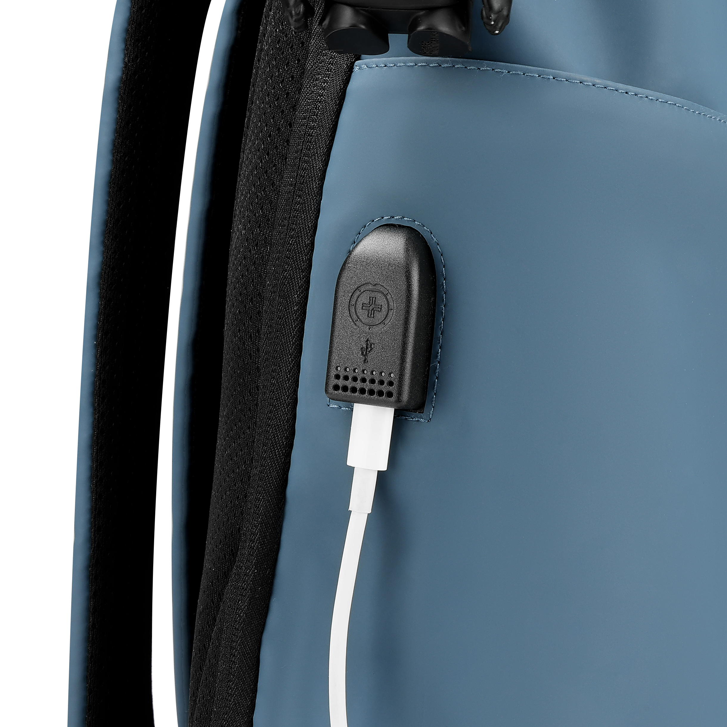 Primo piano di uno zaino blu con porta USB nera e cavo bianco. La cinghia dello zaino è visibile.