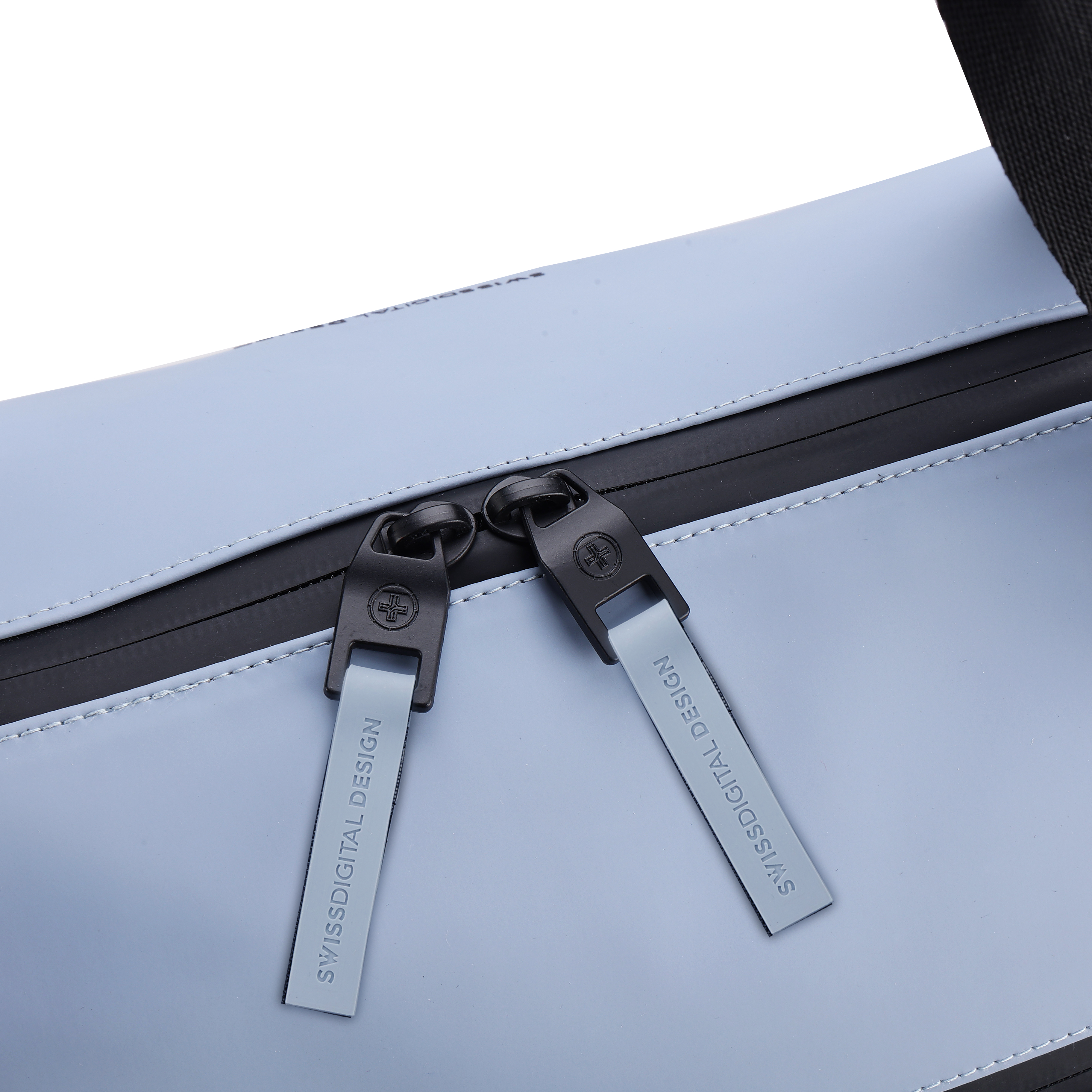 Primo piano di una borsa azzurra con cerniere nere. Le cerniere riportano la scritta SWISSDIGITAL DESIGN.