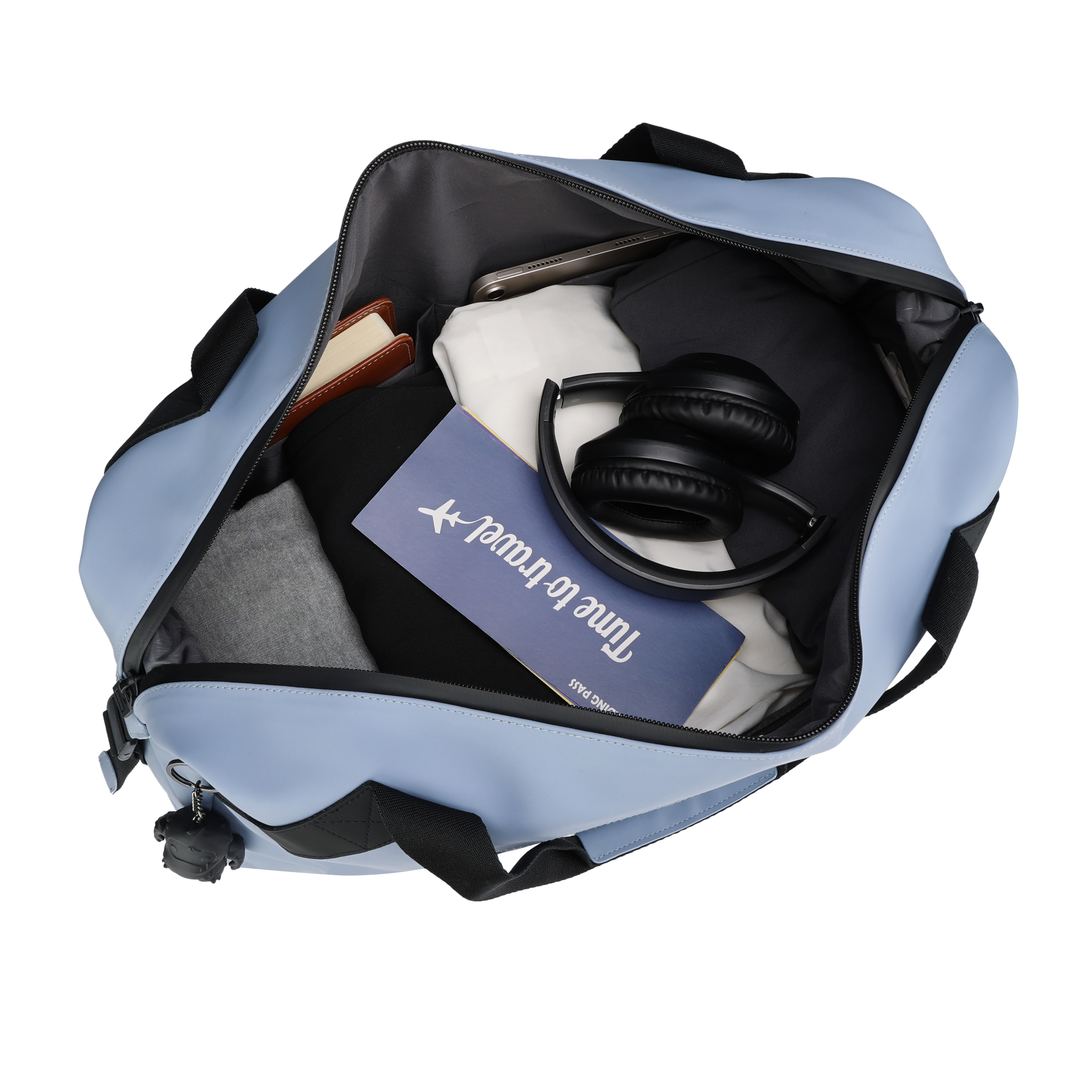 Una borsa da viaggio blu aperta, piena di vestiti, cuffie, un passaporto e un taccuino. Isolato su bianco.