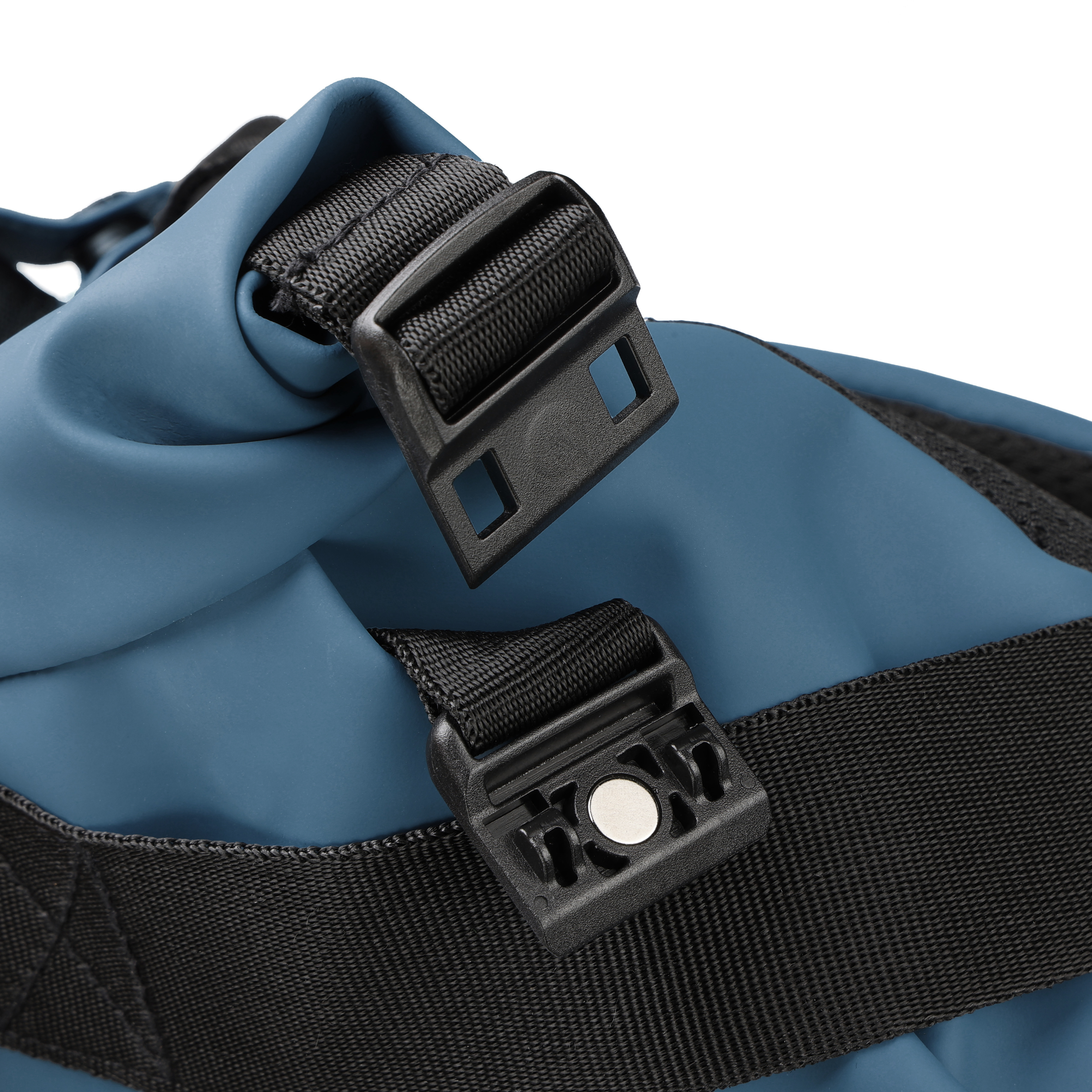 Primo piano di una borsa blu con cinghie e fibbie nere. Le fibbie sono di plastica e le cinghie in tessuto.