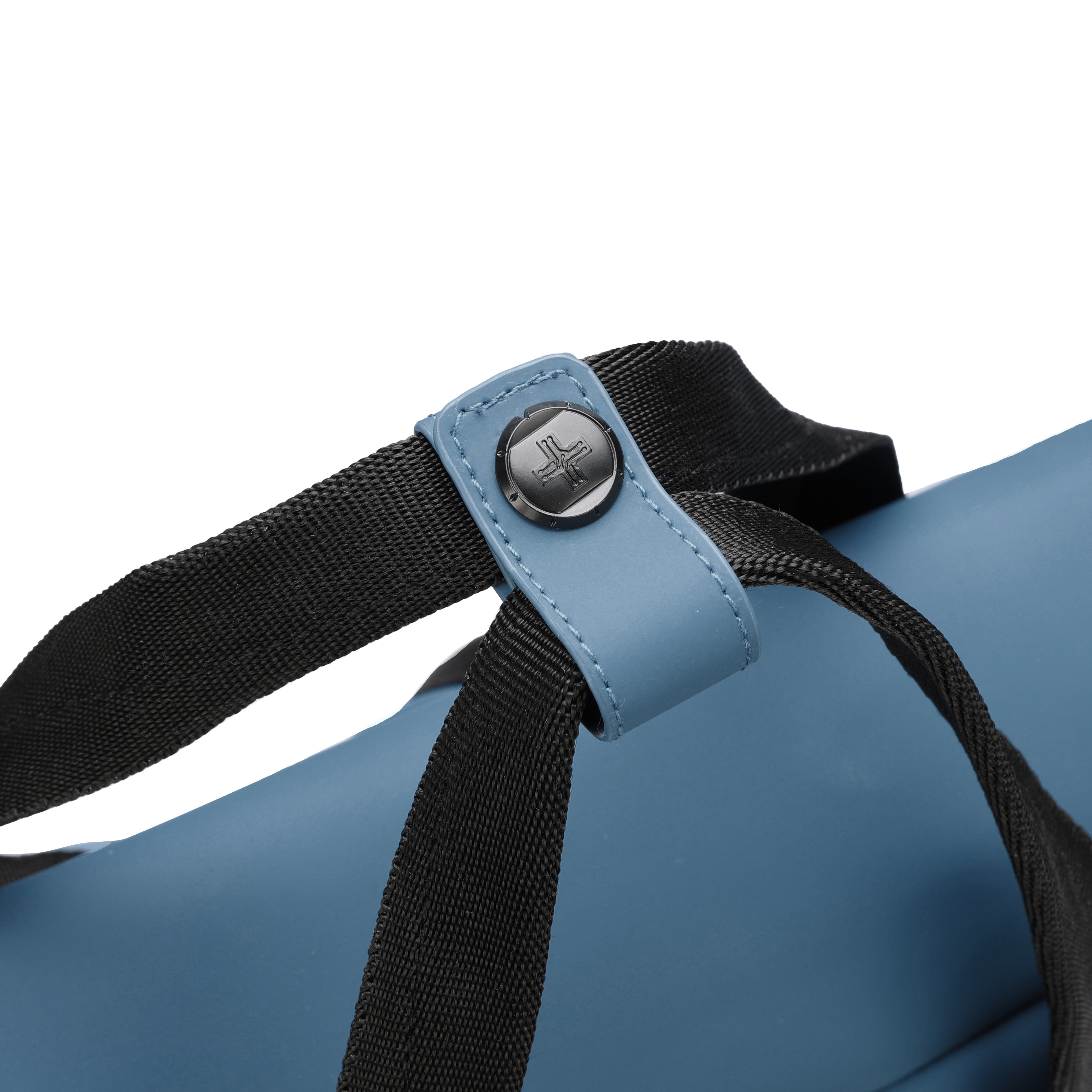 Primo piano di un manico di borsa blu con cinturino nero. È visibile un bottone nero con logo.