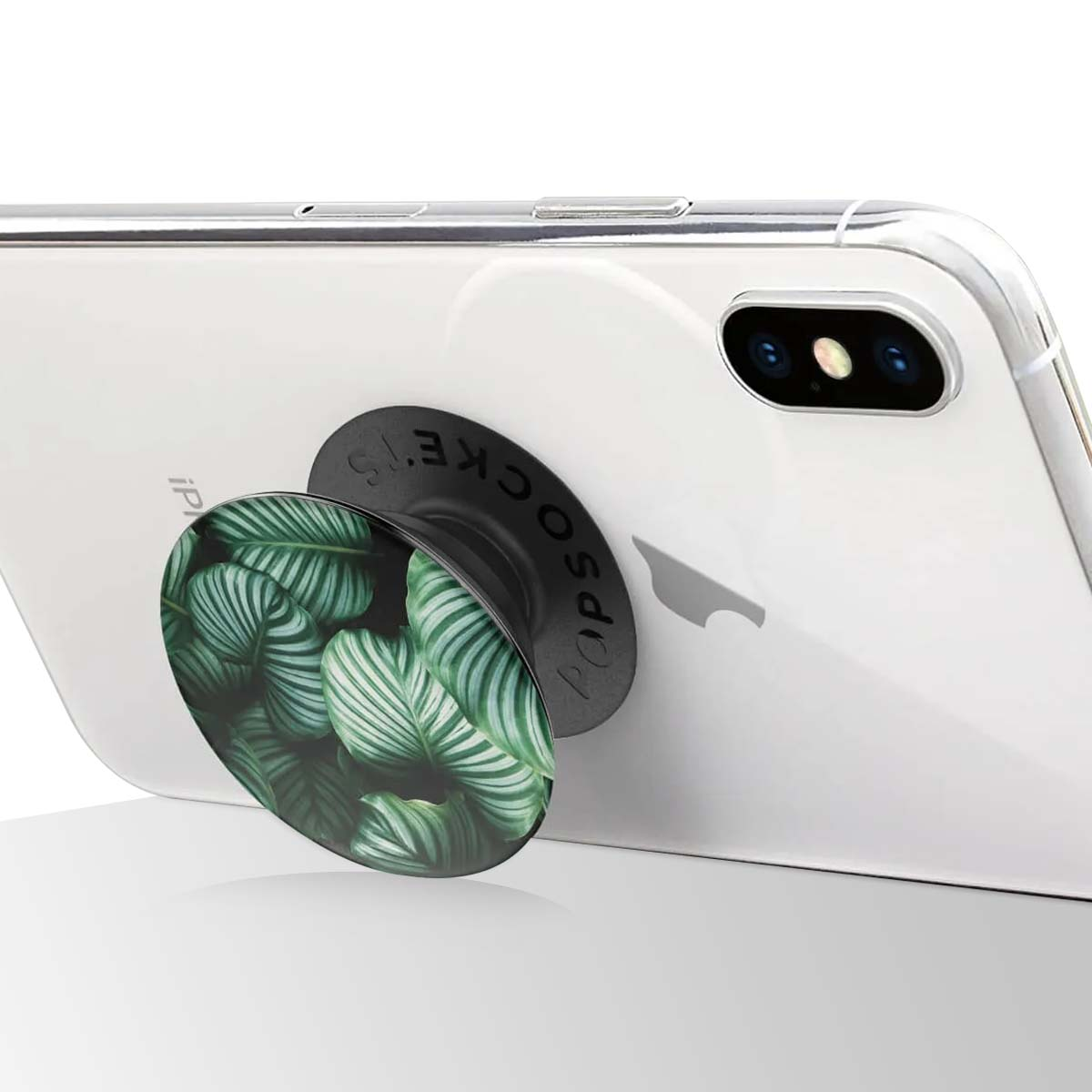 Ein weißes iPhone mit einem PopSocket. Der PopSocket hat ein grünes Blattmuster. Das Telefon ist angewinkelt und zeigt die Rückseite.