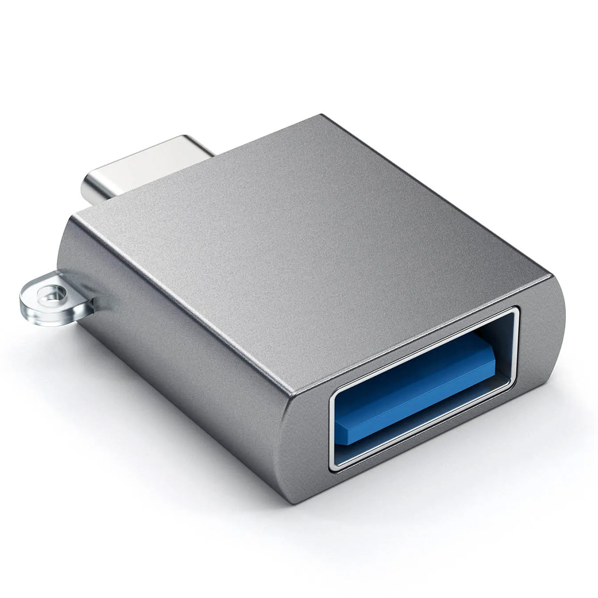 Srebrny adapter USB na białej powierzchni. Posiada port USB-A z niebieskim wnętrzem i złącze USB-C.