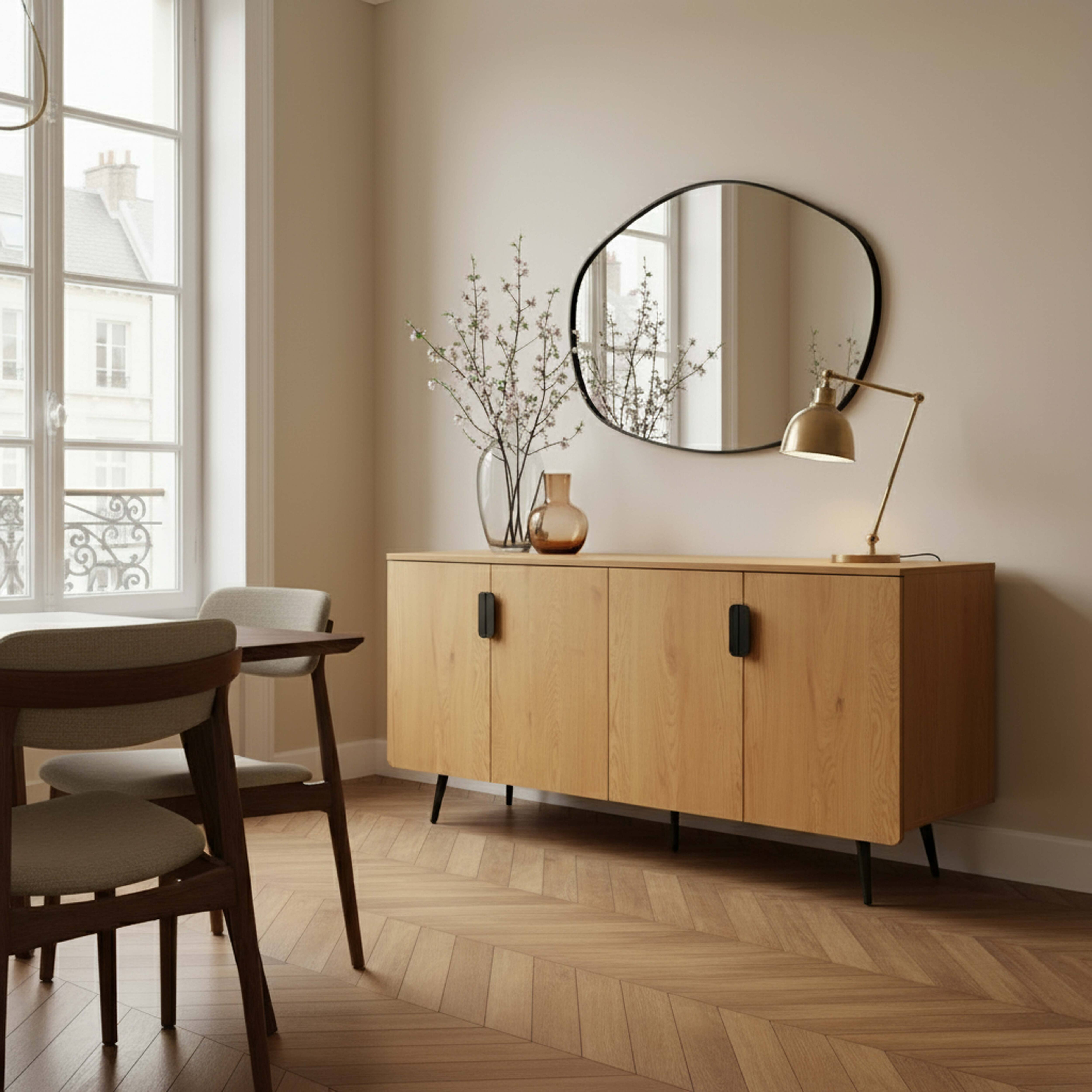 Ein Zimmer mit Holzmöbeln. Auf einem Schrank stehen ein Spiegel, Blumen und eine Lampe. Ein Fenster und Stühle sind sichtbar.