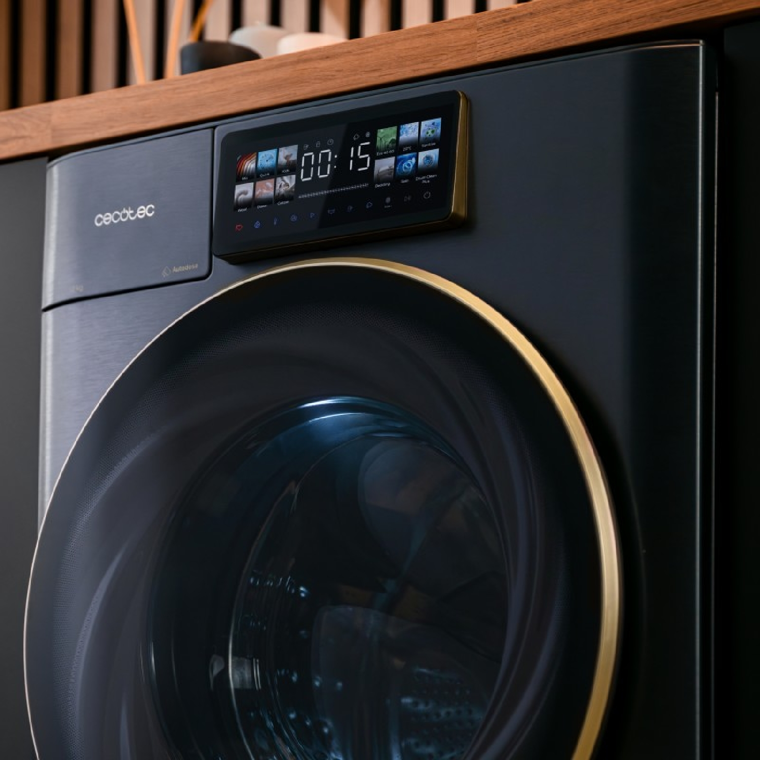 Una lavadora negra moderna con borde dorado y pantalla digital que muestra la configuración. Encimera de madera al fondo.