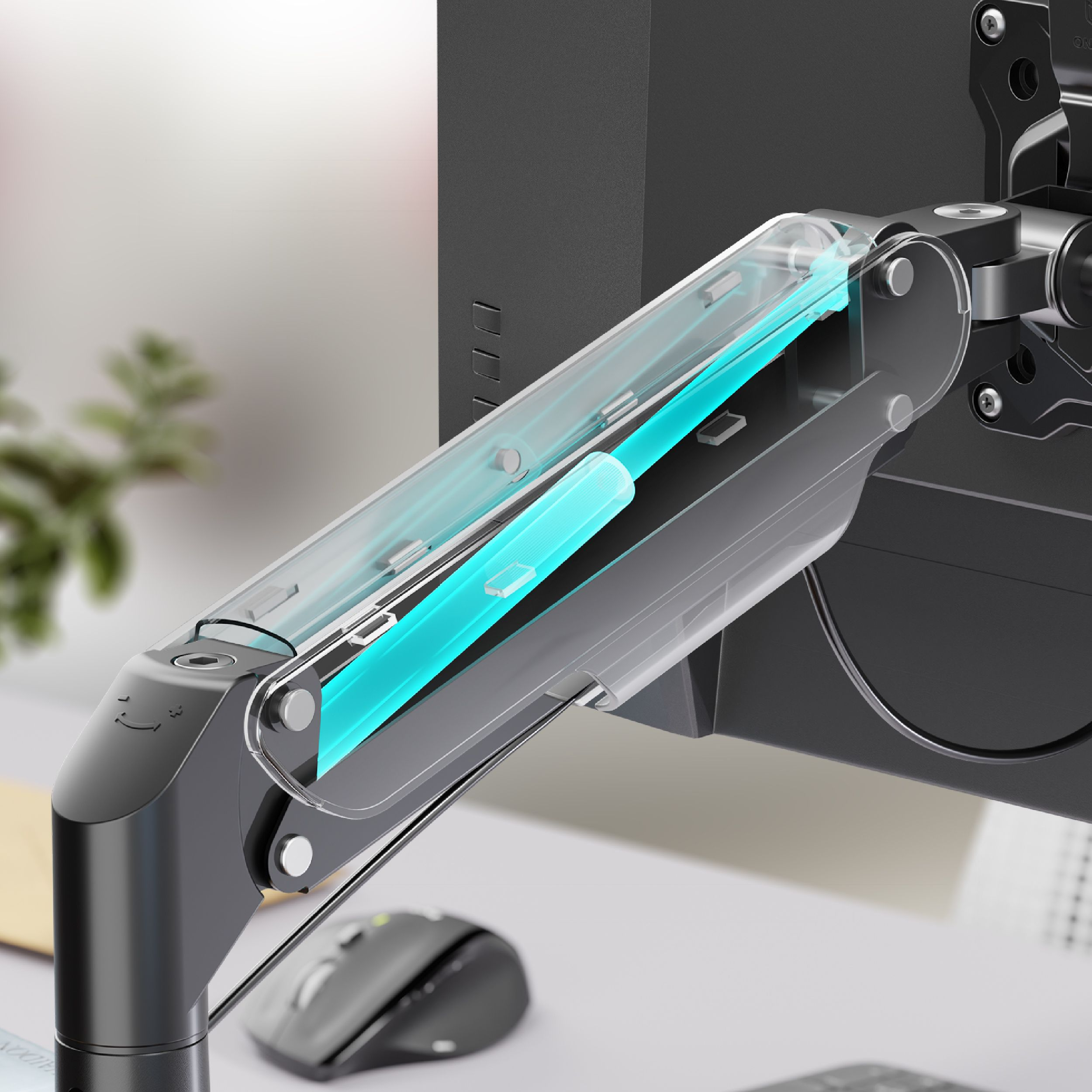 Ramię monitora z przezroczystą, podświetlaną na niebiesko sekcją. Widoczny jest monitor komputera. Obecna jest również mysz i biurko.