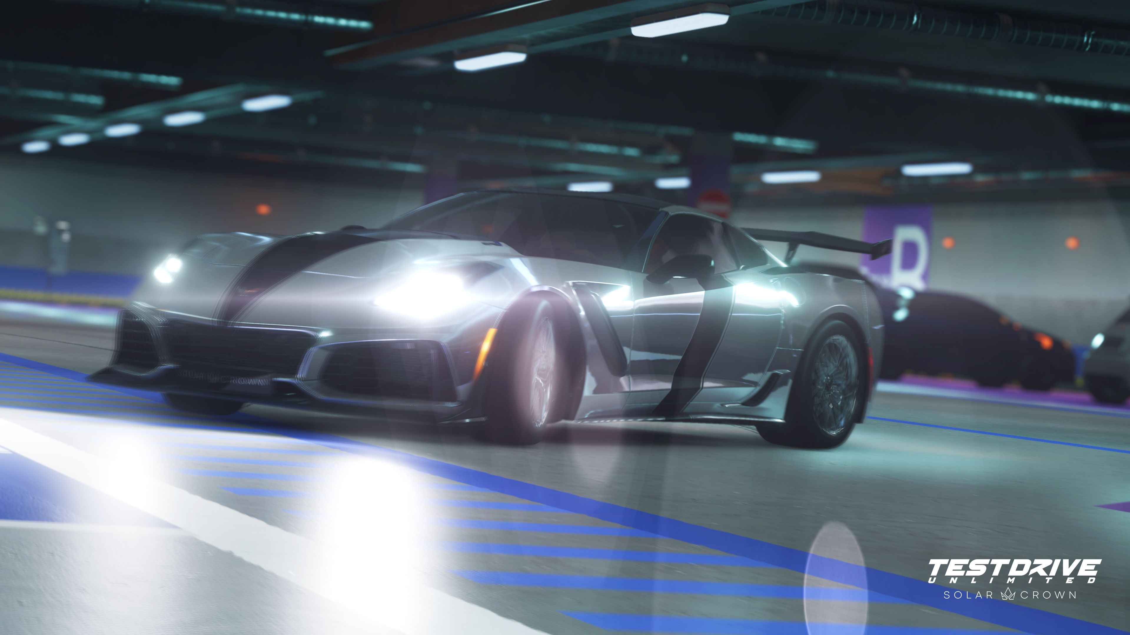 Un'auto sportiva argentata con strisce nere in un garage. I fari sono luminosi. Il logo Test Drive Unlimited è visibile.
