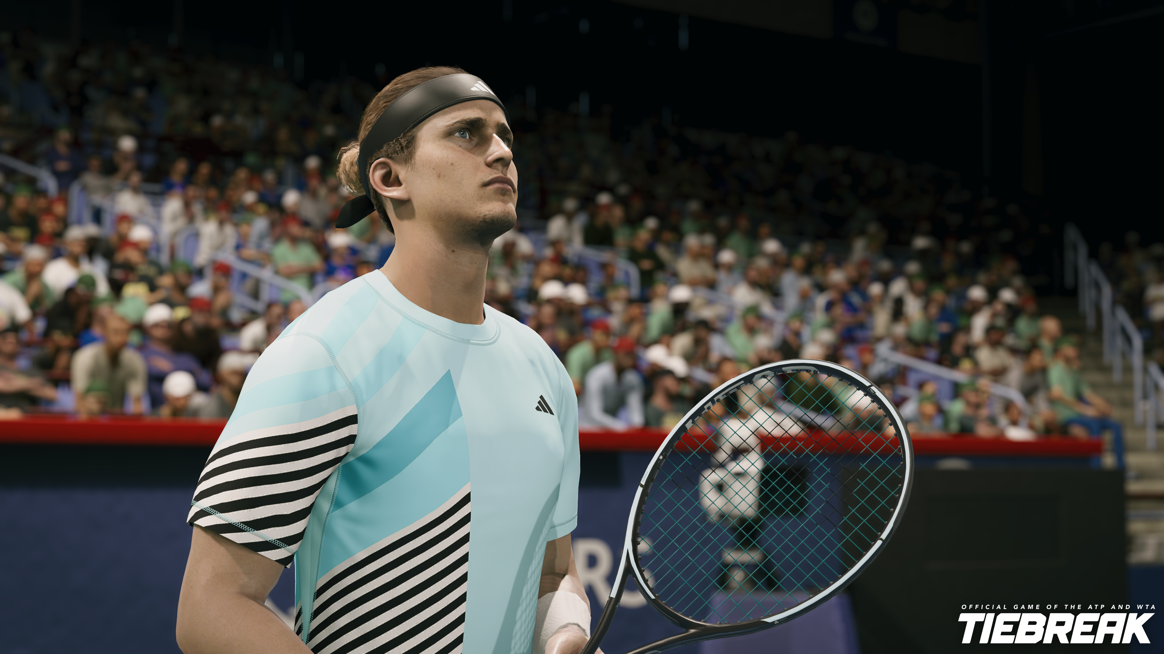 Ein Tennisspieler in hellblauem Hemd mit Schläger. Im Hintergrund eine verschwommene Menschenmenge, die dem Spiel zusieht.