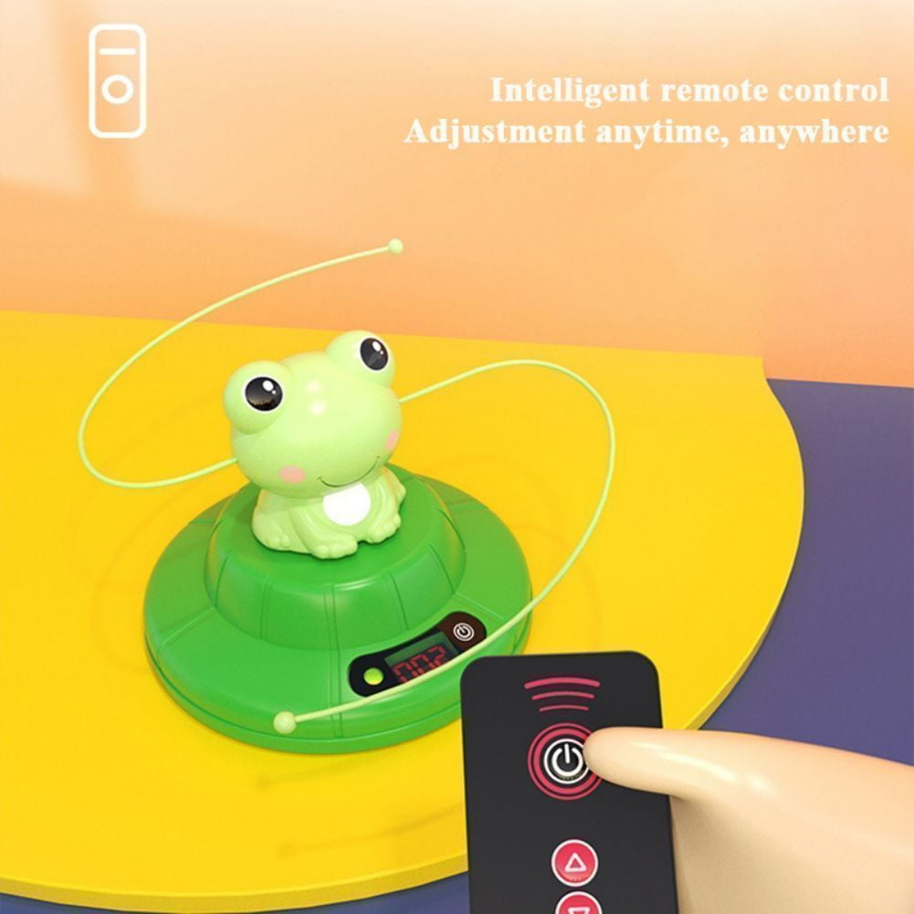 Ein grünes Froschspielzeug sitzt auf einer grünen Basis mit Digitalanzeige. Eine Fernbedienung ist im Vordergrund.