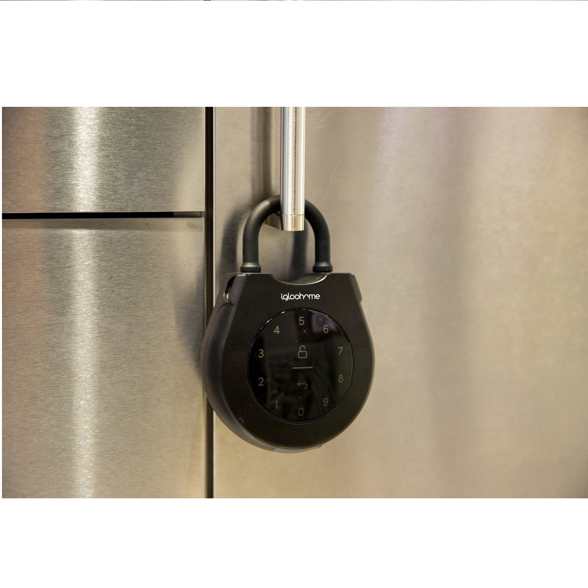Ein schwarzes Igloohome-Schloss hängt. Das Schloss hat eine Tastatur mit Zahlen. Es ist an einer Metalloberfläche befestigt.