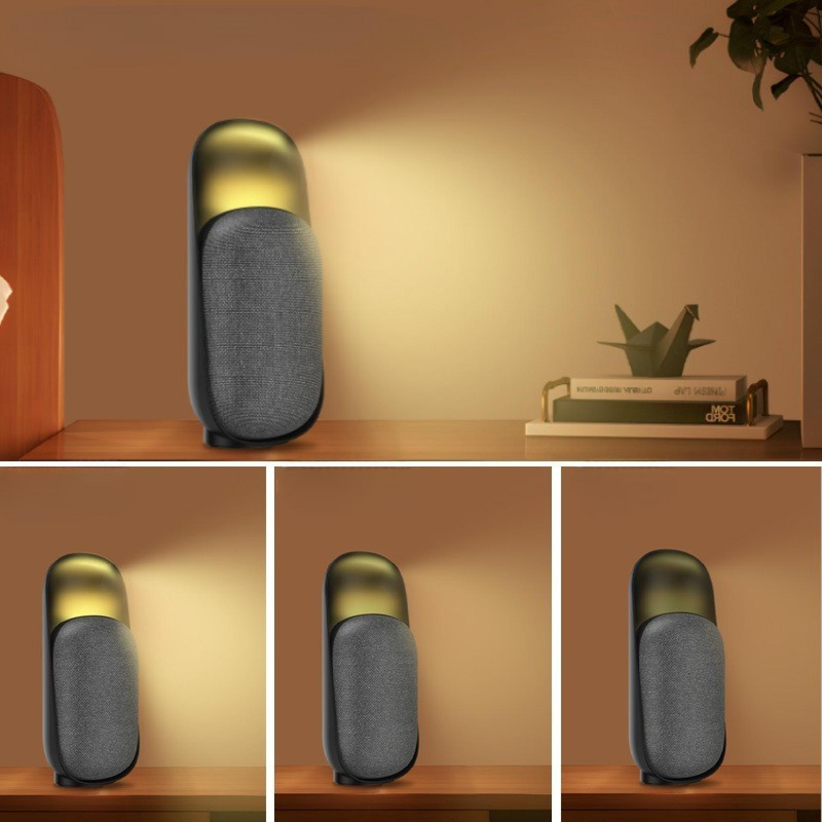 Eine moderne Lampe mit goldenem Oberteil und grauem Stoff auf einer Holzoberfläche. Bücher und ein Papier-Vogel im Hintergrund.