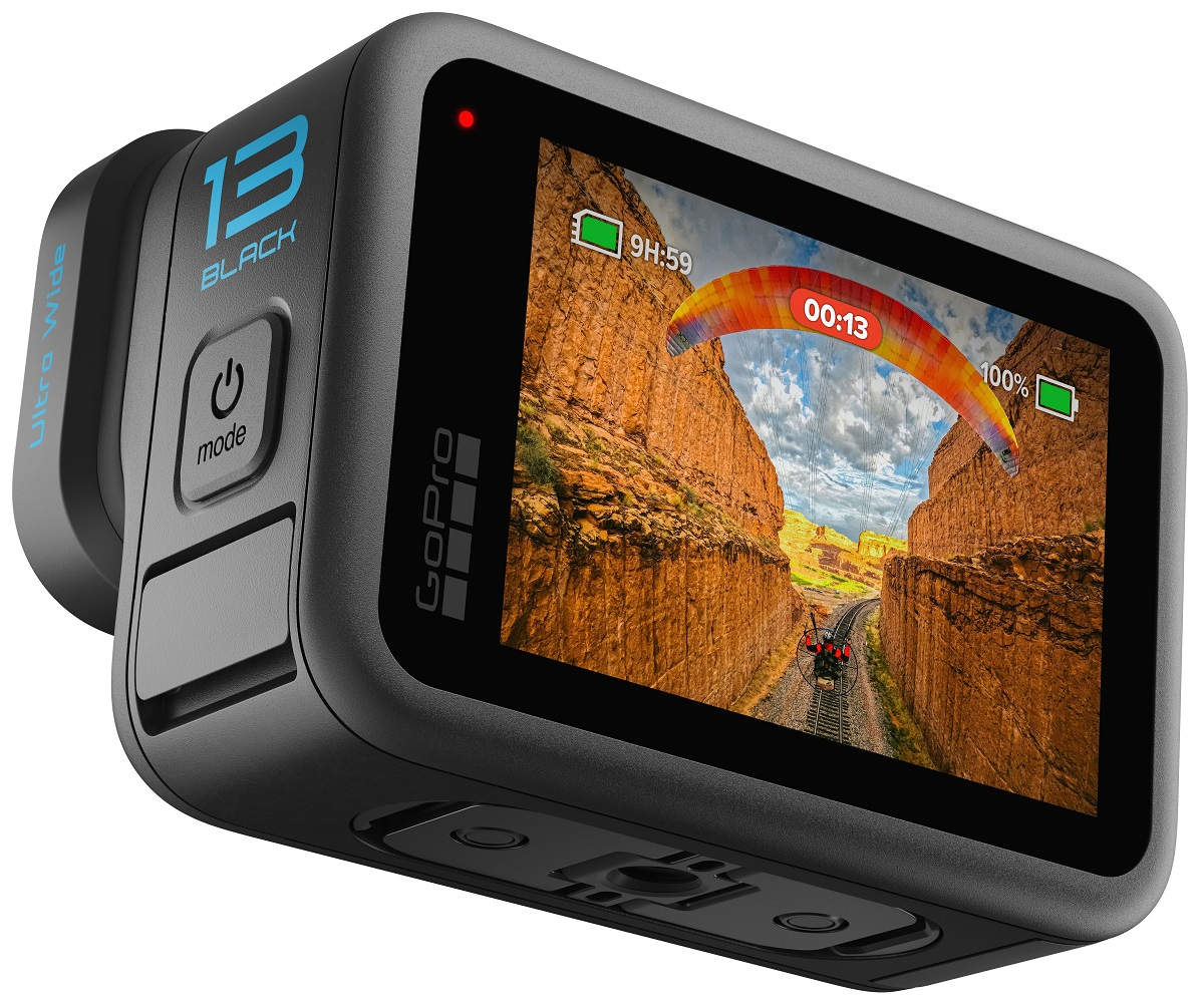 Czarna kamera GoPro wyświetlająca paralotnię w kanionie. Ekran pokazuje czas, baterię i przycisk zasilania.