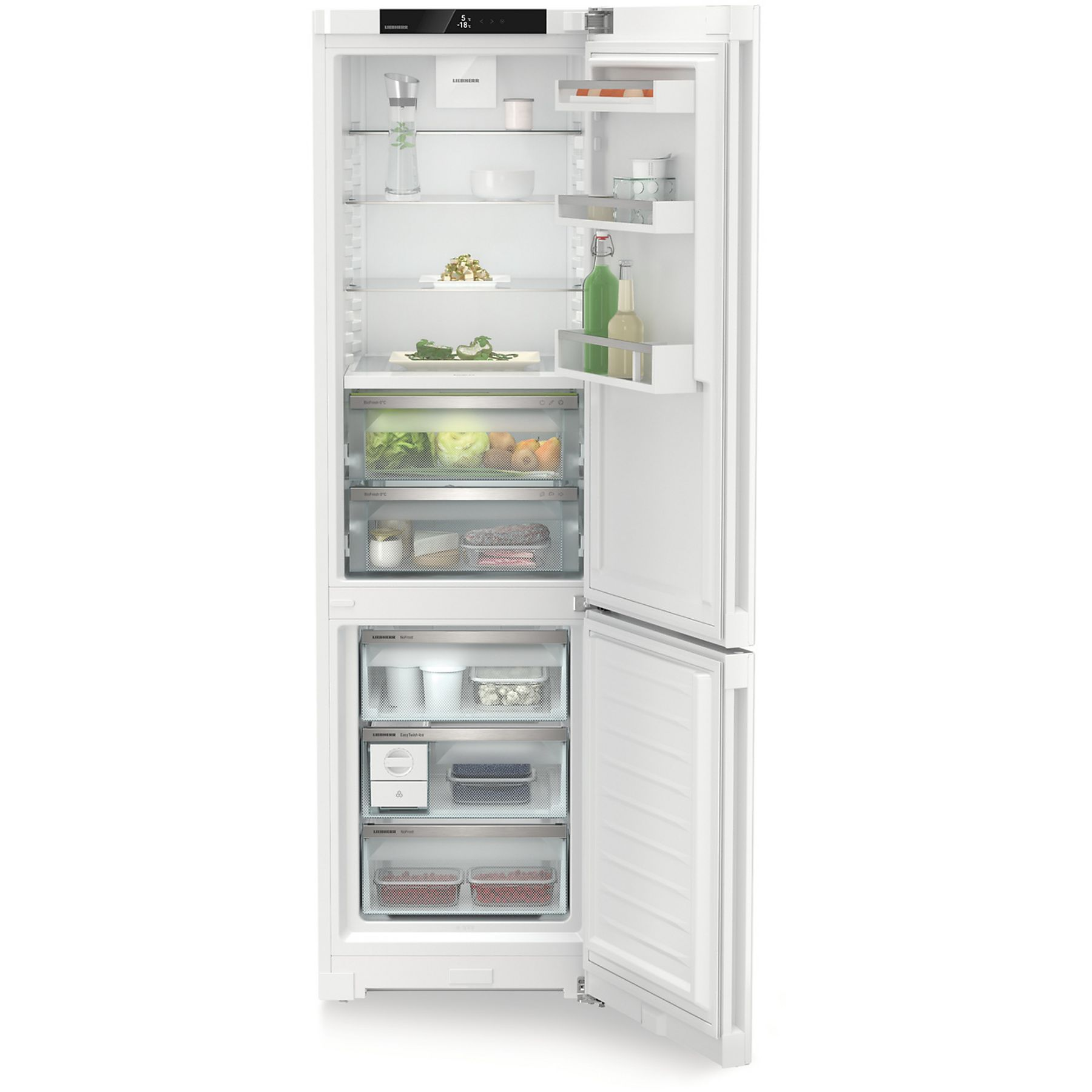Refrigerador blanco abierto con estantes y cajones llenos de comida. Botellas y recipientes verdes son visibles.