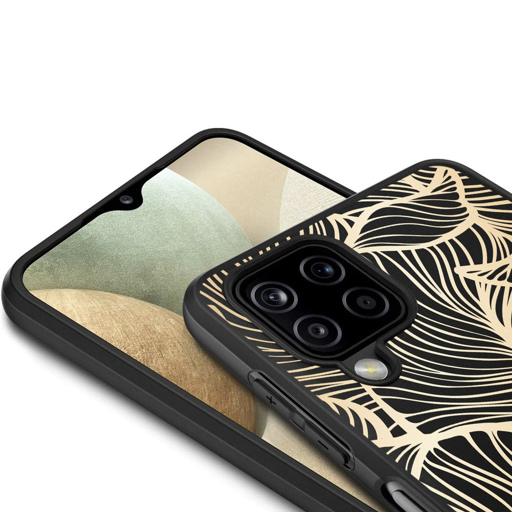 Close-up van een telefoon in een zwarte hoes met een gouden bladeren ontwerp. Een andere telefoon eronder. De achtergrond is een vage lichte kleur.