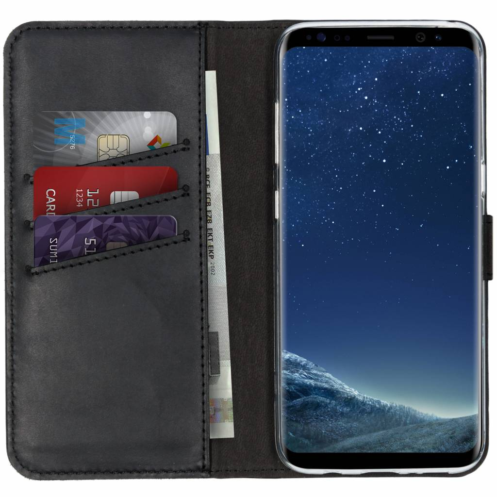 Schwarze Leder-Handyhülle mit Kreditkarten, einer Rechnung und einem Smartphone mit Sternenhimmel.