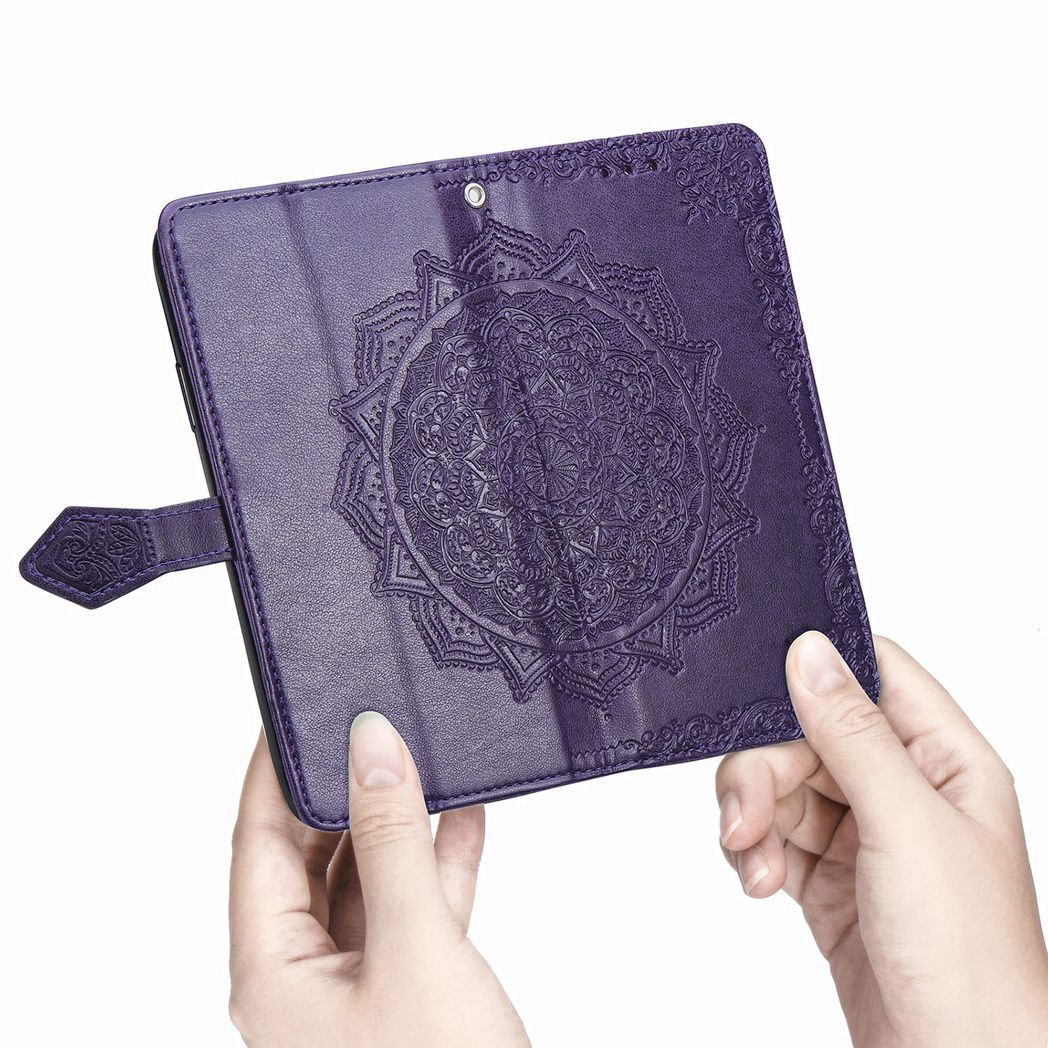 Mains tenant un étui de tablette violet avec un motif de mandala. L'étui a une fermeture magnétique et des coutures décoratives.