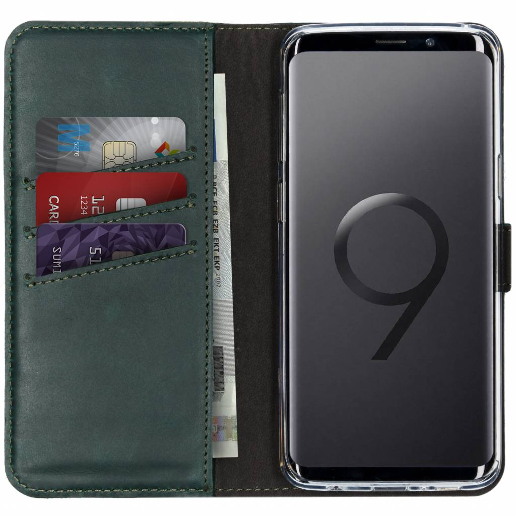 Étui de téléphone en cuir vert avec téléphone, cartes de crédit et argent. Le téléphone affiche un grand 9.