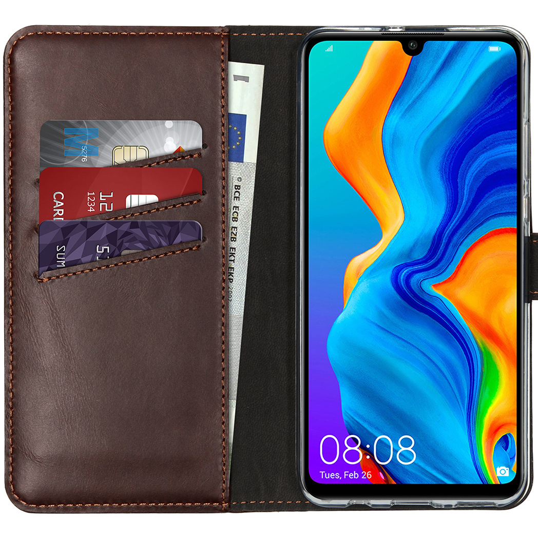Un étui de téléphone en cuir marron avec un téléphone à l'intérieur. L'étui contient des cartes et un billet en euros. Le téléphone affiche : 08:08, mar. 26 fév.