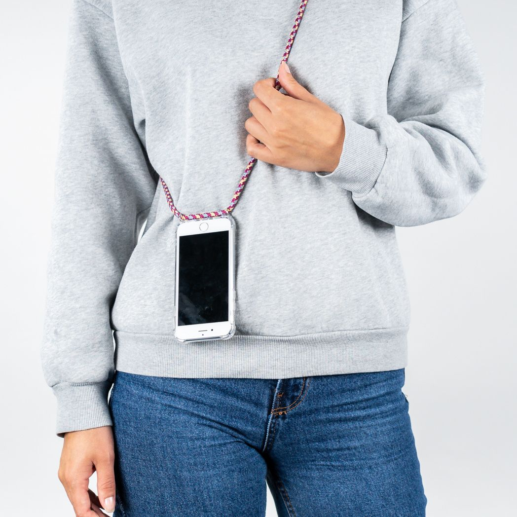 Persoon draagt ​​grijze trui en een blauwe jeans, en houdt een telefoon met een koord vast. De telefoon zit in een doorzichtig hoesje.