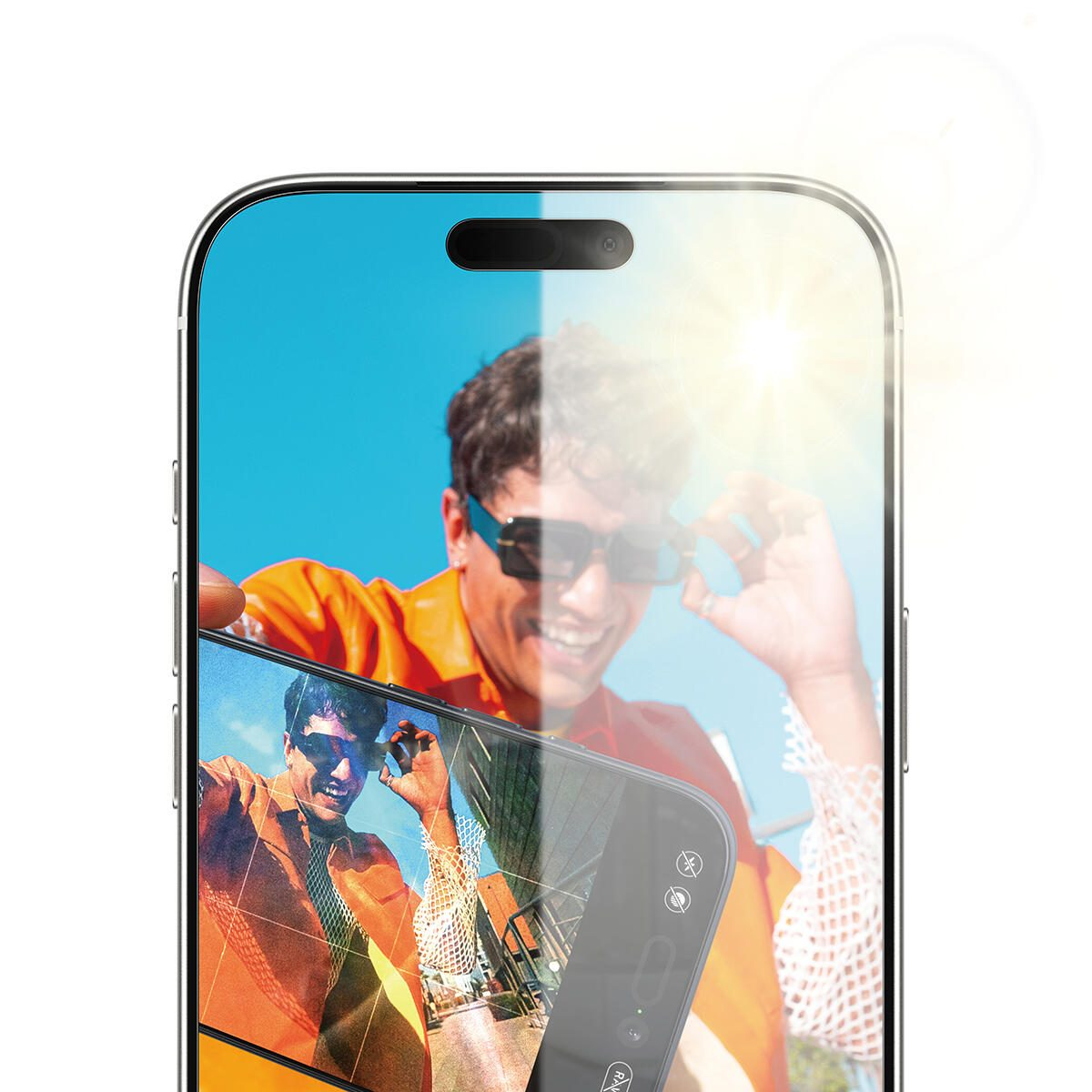 Un uomo con occhiali da sole sorride tenendo un telefono che mostra una foto di se stesso. La luce del sole splende sul telefono e sull'uomo.