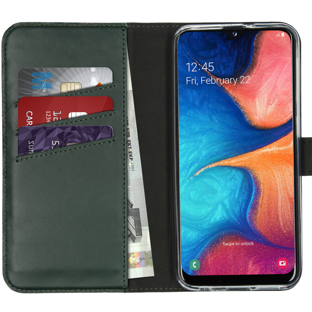 Een telefoon in een groene portemonneehoes met creditcards en contant geld. De telefoon geeft de tijd en een kleurrijke abstracte achtergrond weer.