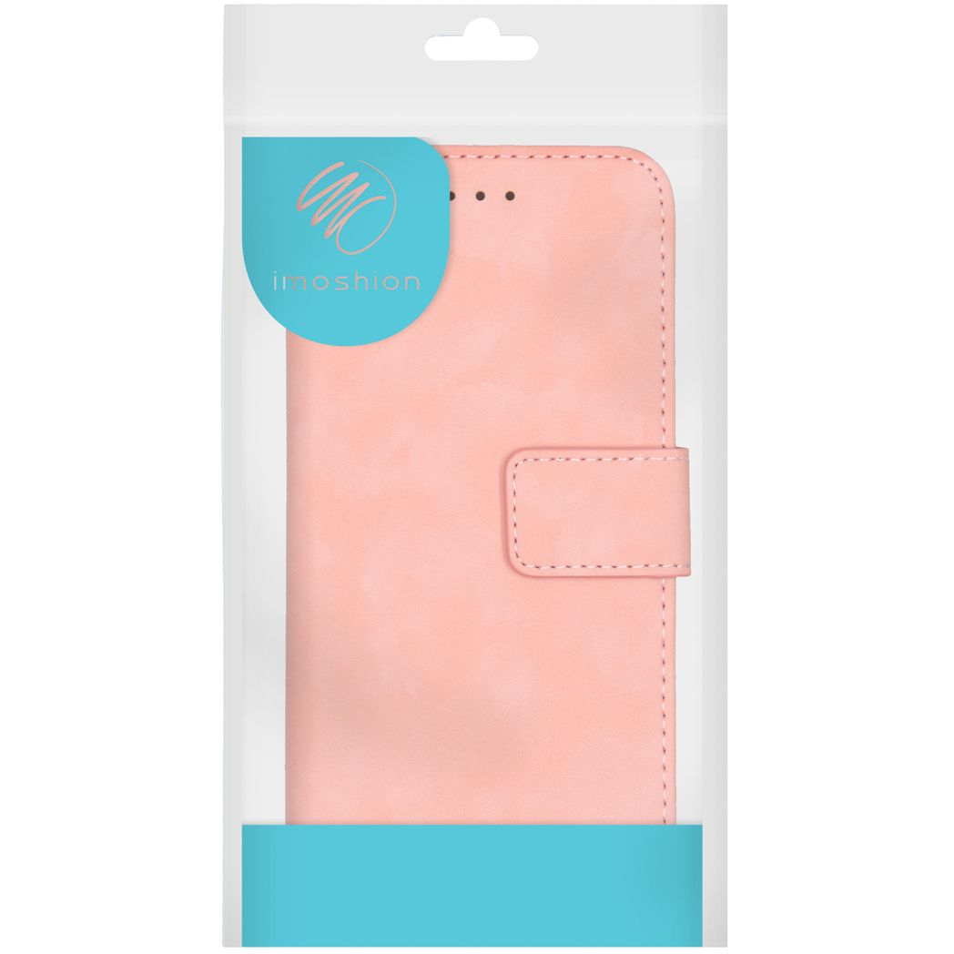 Een roze telefoonhoes in een doorzichtige plastic verpakking. De hoes heeft een magneetsluiting. De merknaam is 'imoshion'.