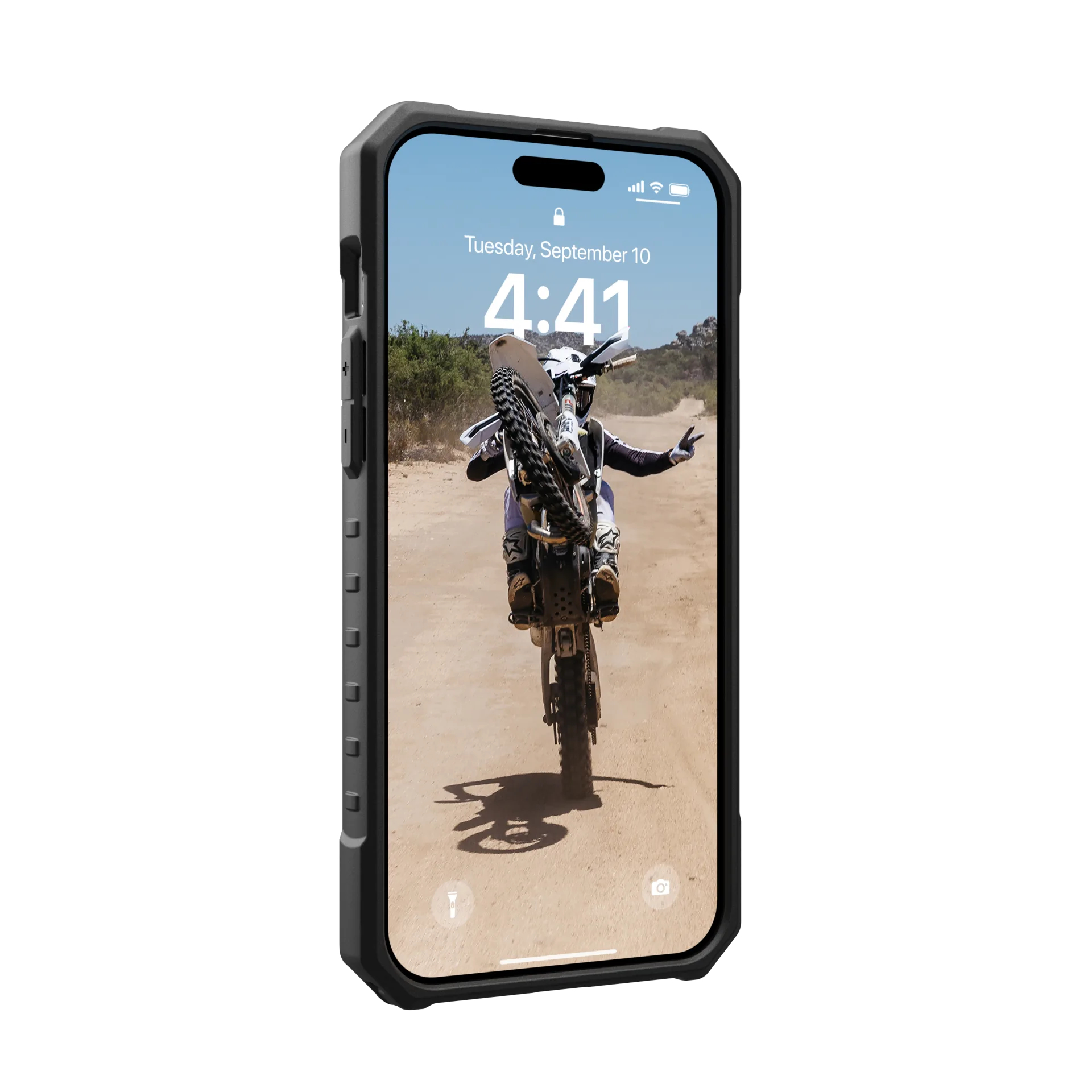 Ein Telefon in einem Gehäuse zeigt einen Motocross-Fahrer auf einem Motorrad, der einen Wheelie auf einer Dirt-Road macht.