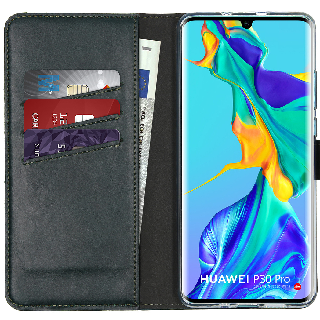 Un étui de téléphone avec un téléphone à l'intérieur, des cartes de crédit et un billet. Le téléphone est un Huawei P30 Pro.