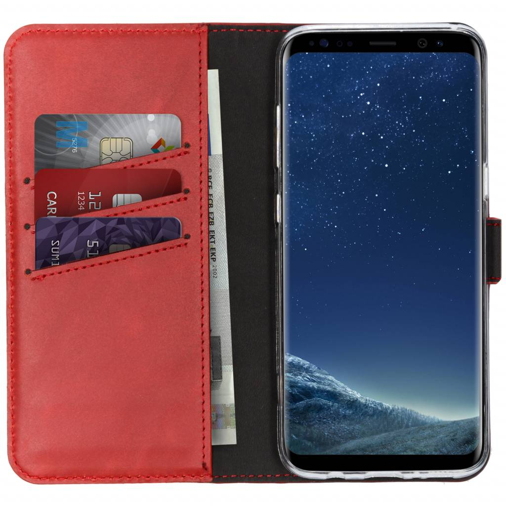 Rote Handyhülle mit Smartphone. Die Hülle enthält Karten und Geld. Das Telefon zeigt eine Sternennacht.