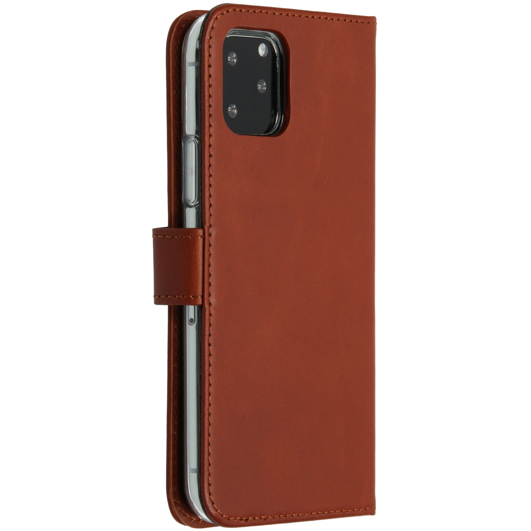 Un étui de téléphone en cuir marron est ouvert, révélant un smartphone. L'étui a une fermeture magnétique et des coutures. Le téléphone a une caméra.