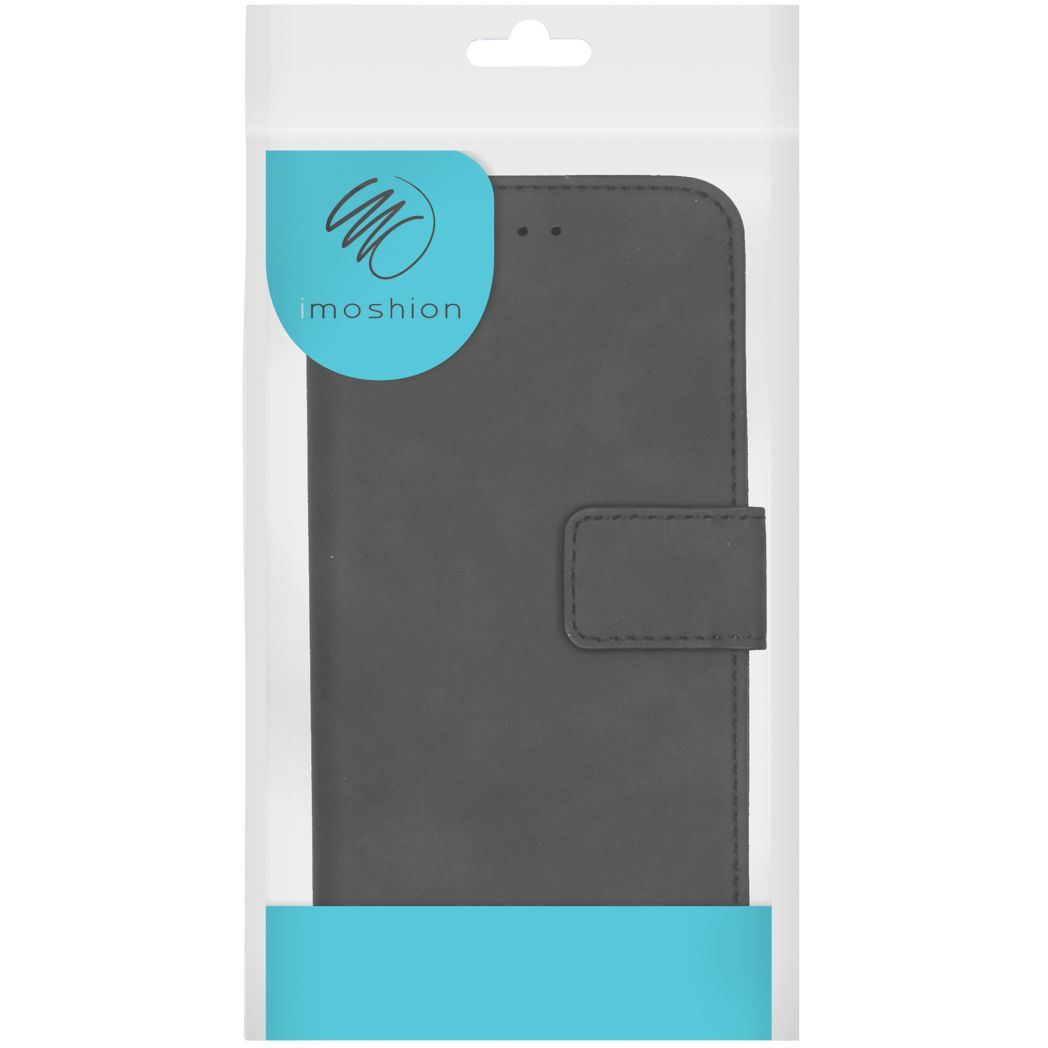 Une coque de téléphone dans un emballage plastique transparent. L'étui est noir avec un fermoir magnétique. L'emballage a également un logo : imoshion.