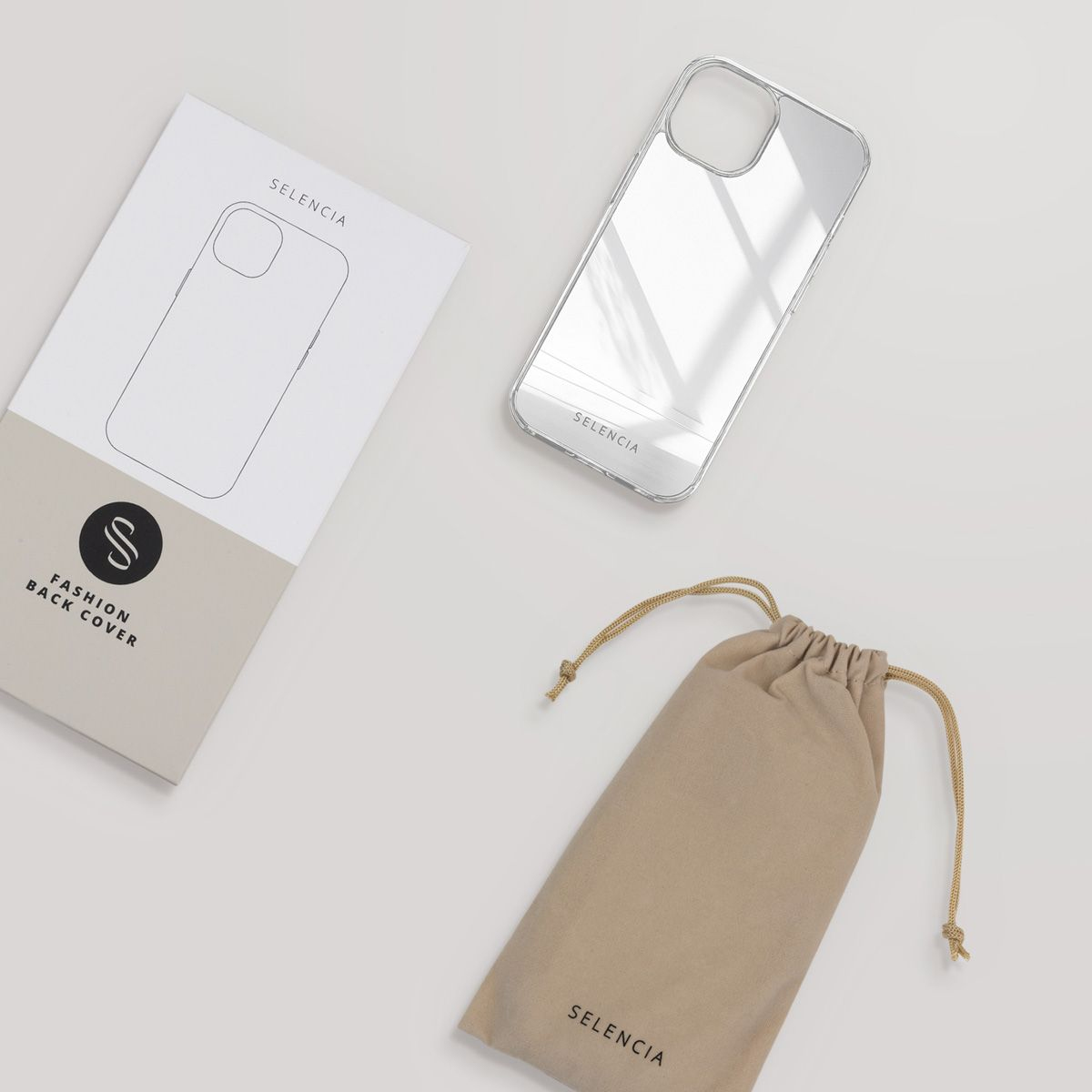 Een bovenaanzicht toont een telefoonhoesje, verpakking en een tas. Allemaal gebrand met 'Selencia'. De hoes is doorzichtig en reflecteert licht.