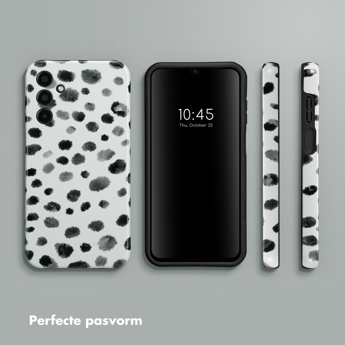 Een telefoon en twee hoesjes met een dalmatiërpatroon. Telefoon toont 10:45. Hoesjes en telefoon op een grijze ondergrond.