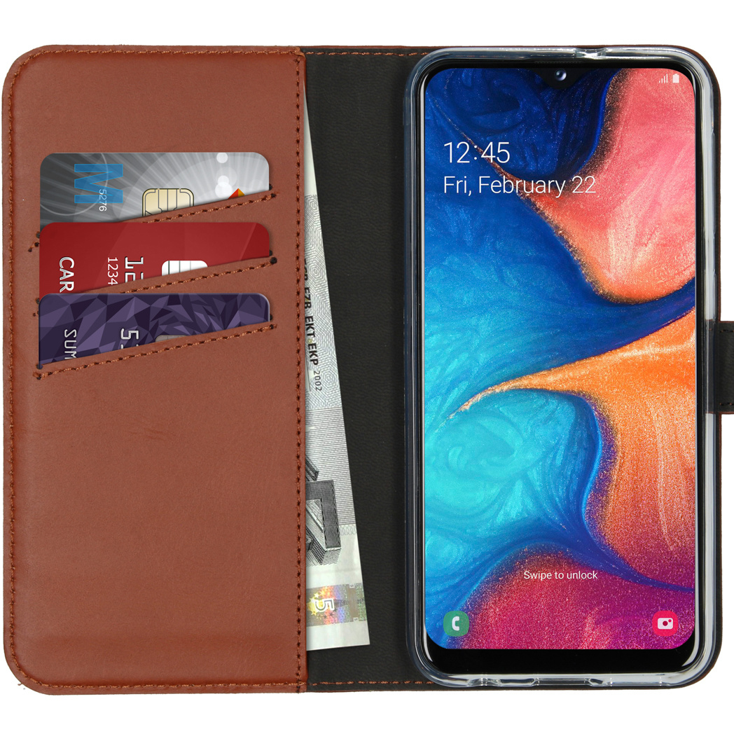 Un étui de téléphone en cuir marron avec un téléphone affichant l'heure. Des cartes de crédit et un billet sont visibles à l'intérieur de l'étui.