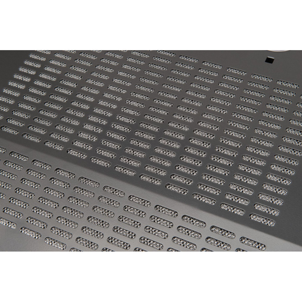 Zbliżenie ciemnoszarej metalowej powierzchni z licznymi, równomiernie rozmieszczonymi, podłużnymi otworami. Widoczna siatkowa faktura.