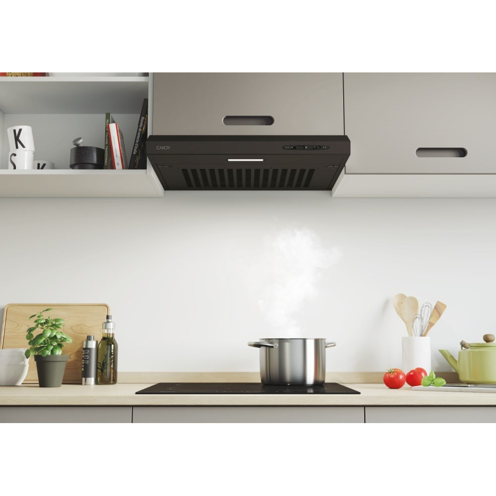 Scena kuchenna. Garnek paruje na płycie kuchennej. Okap nad nim. Warzywa i przybory na blacie, z szafkami nad nim.