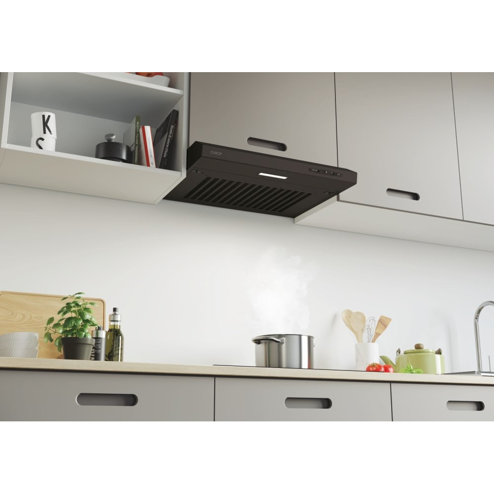 Scena kuchenna z czarnym okapem nad kuchenką z garnkiem. Widoczne są szafki i półki.