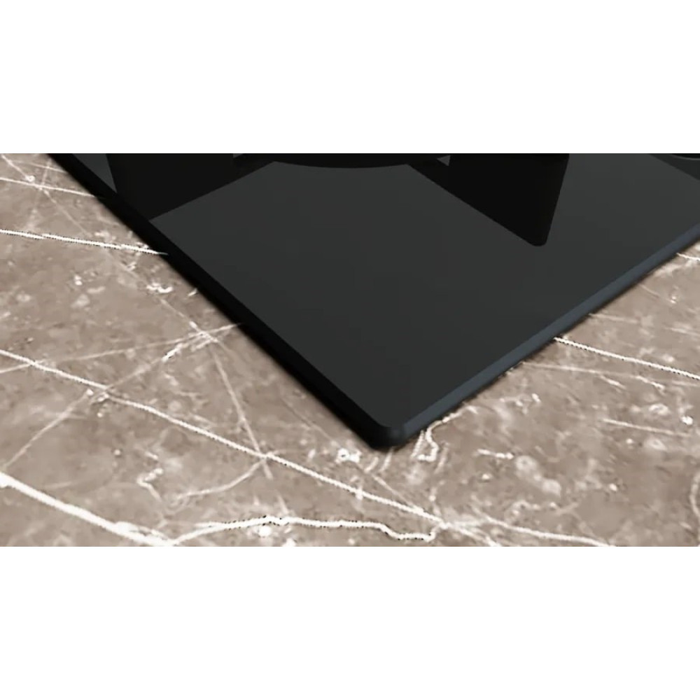 Zbliżenie czarnego, prostokątnego obiektu z zaokrąglonymi rogami na powierzchni o wzorze marmuru.