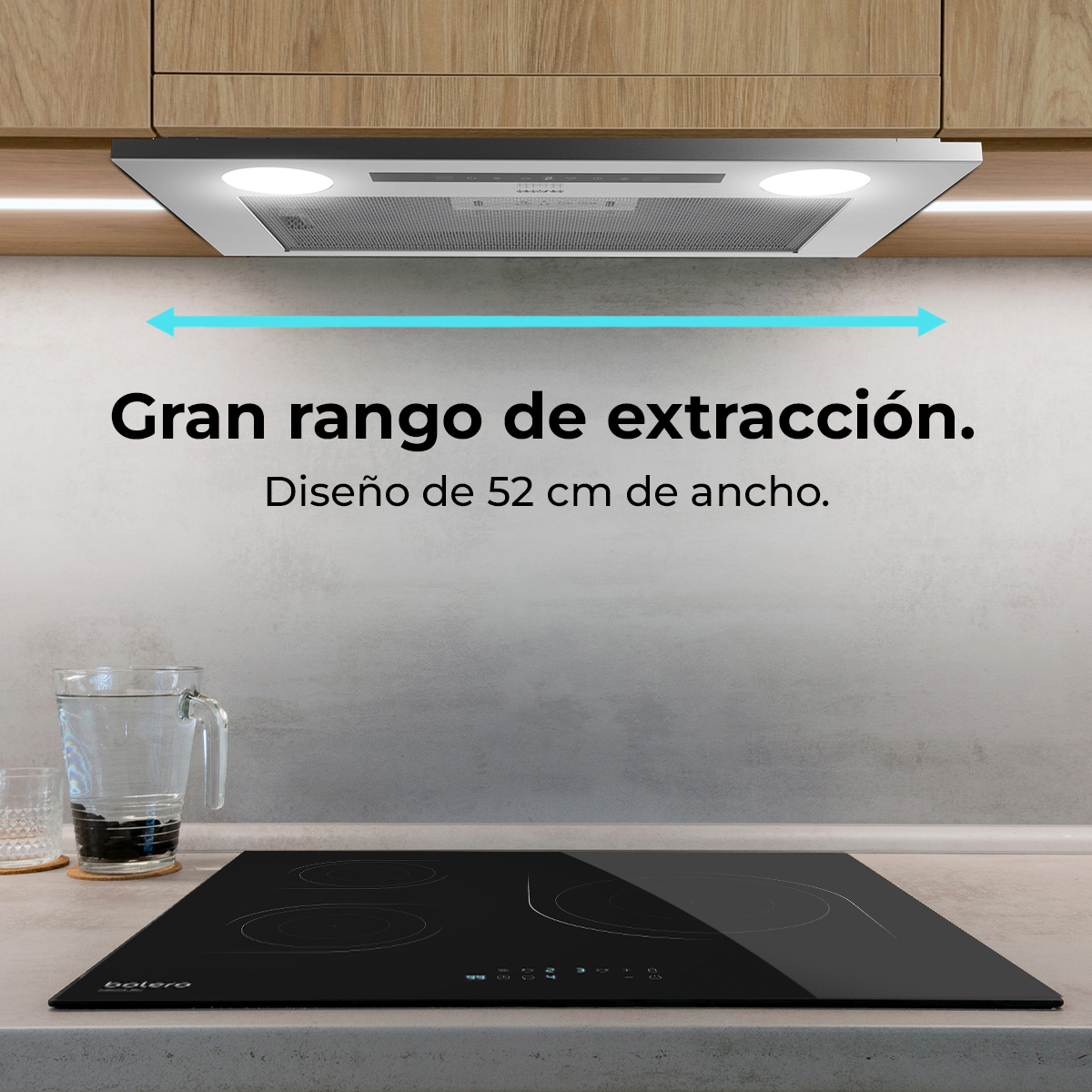 Scena di cucina con piano cottura a induzione nero, cappa e testo in spagnolo. Un bicchiere d'acqua è sul bancone.
