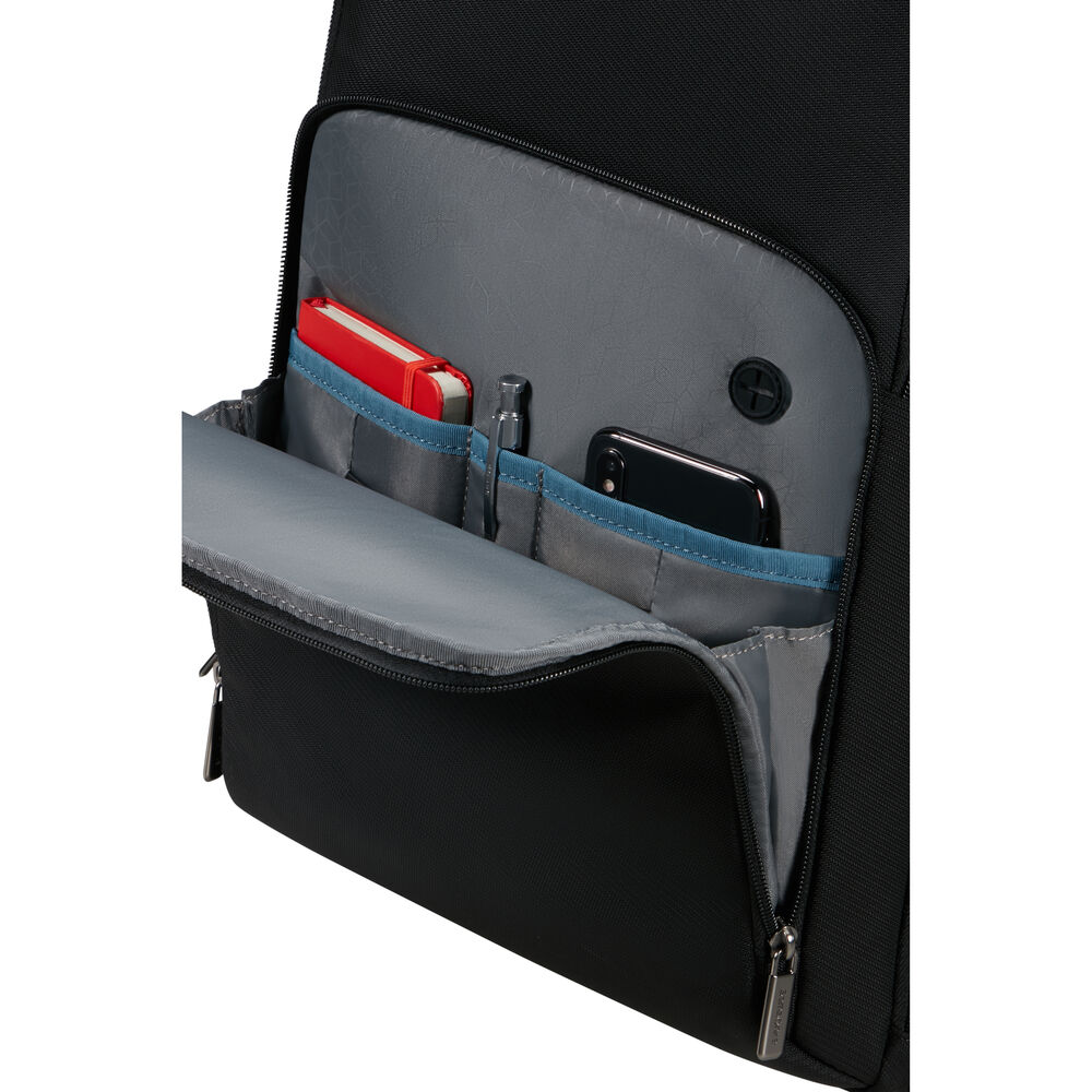 Schwarze Rucksacktasche mit rotem Notizbuch, Stift und Smartphone. Grauer Innenraum mit blauem Rand und schwarzem Reißverschluss.