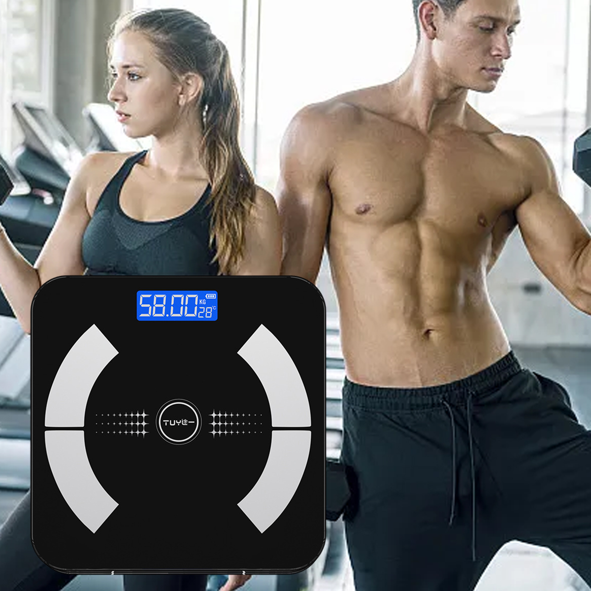 Ein Mann und eine Frau in einem Fitnessstudio, mit einer schwarzen Waage davor. Die Waage zeigt 58,00 kg an. Der Mann ist oben ohne und hebt ein Gewicht.