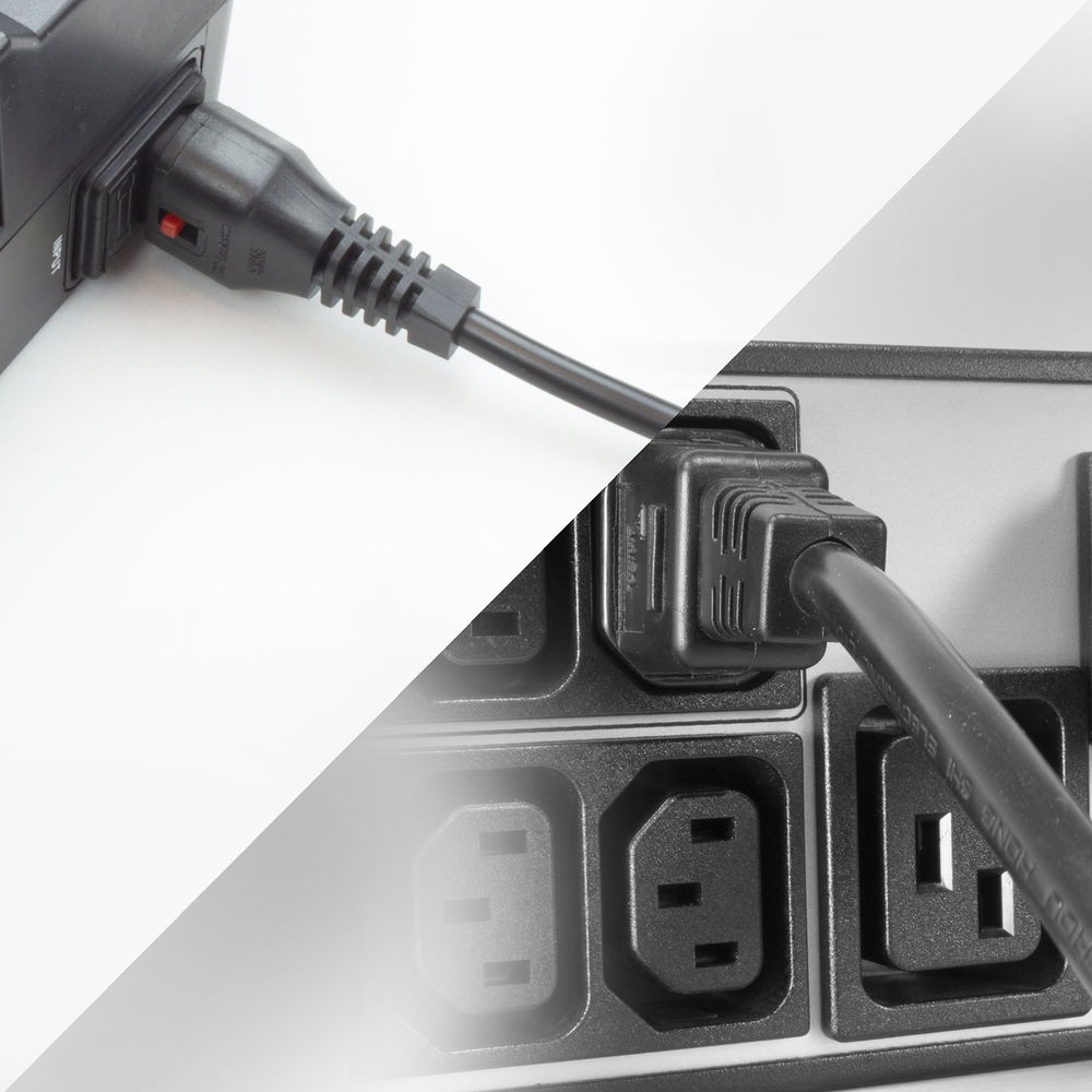 Schwarze Netzkabel stecken in einer schwarzen Steckdosenleiste. Der Hintergrund ist weiß. Ein Kabel ist vollständig eingesteckt, das andere teilweise.