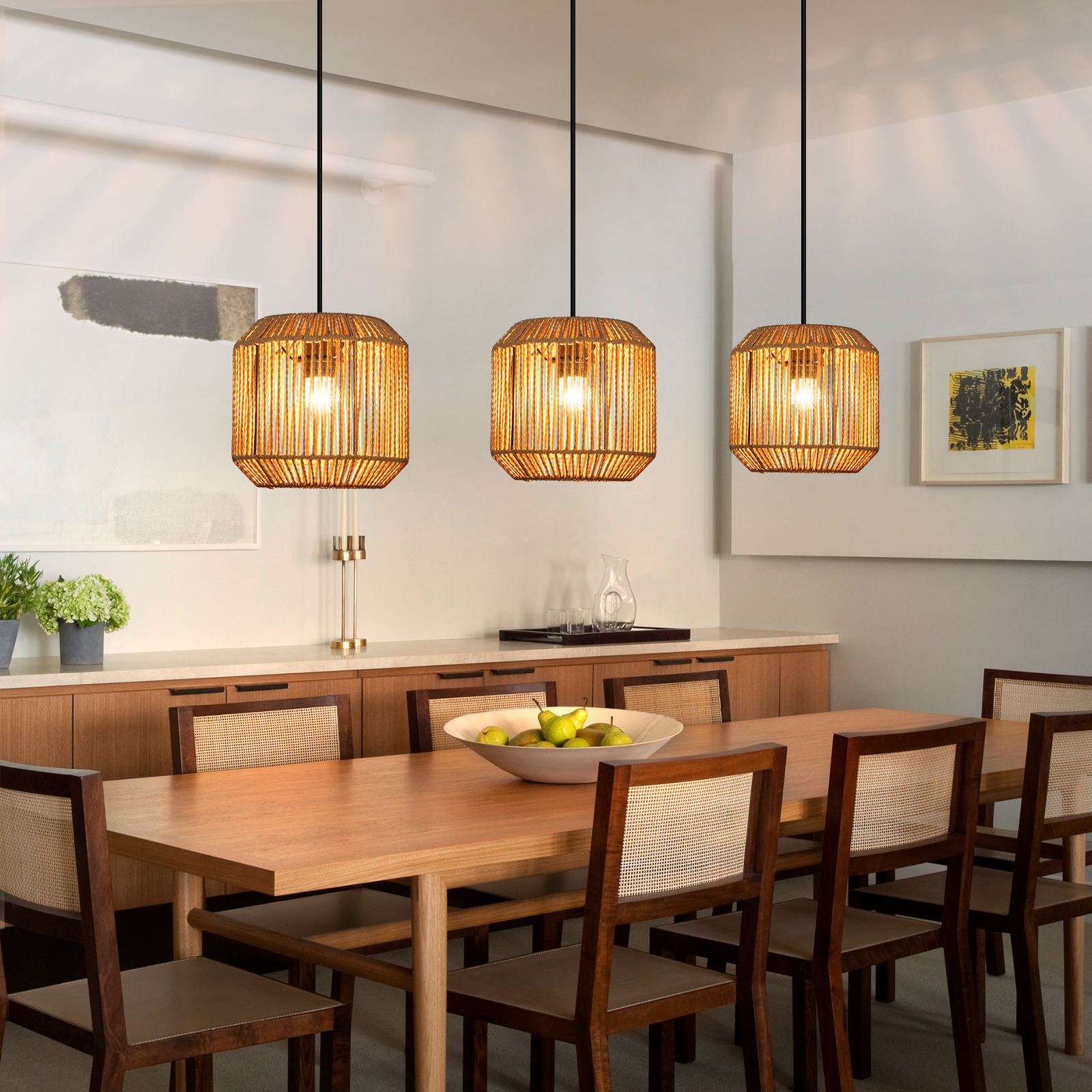 Esszimmer mit Holztisch, Stühlen, Pendelleuchten und einer Schale mit Birnen. Hintergrund: Schrank und Kunstwerk.
