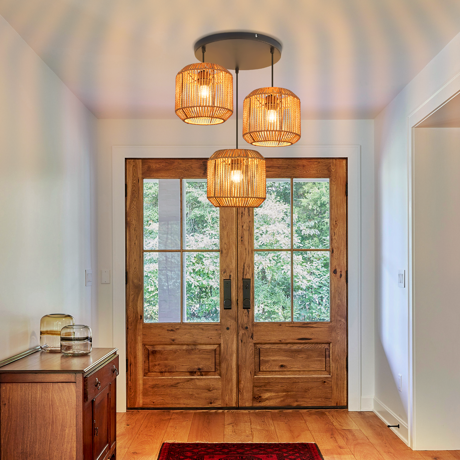 Hol wejściowy z drewnianymi drzwiami, trzema lampami wiszącymi, drewnianą szafką i czerwonym dywanem.
