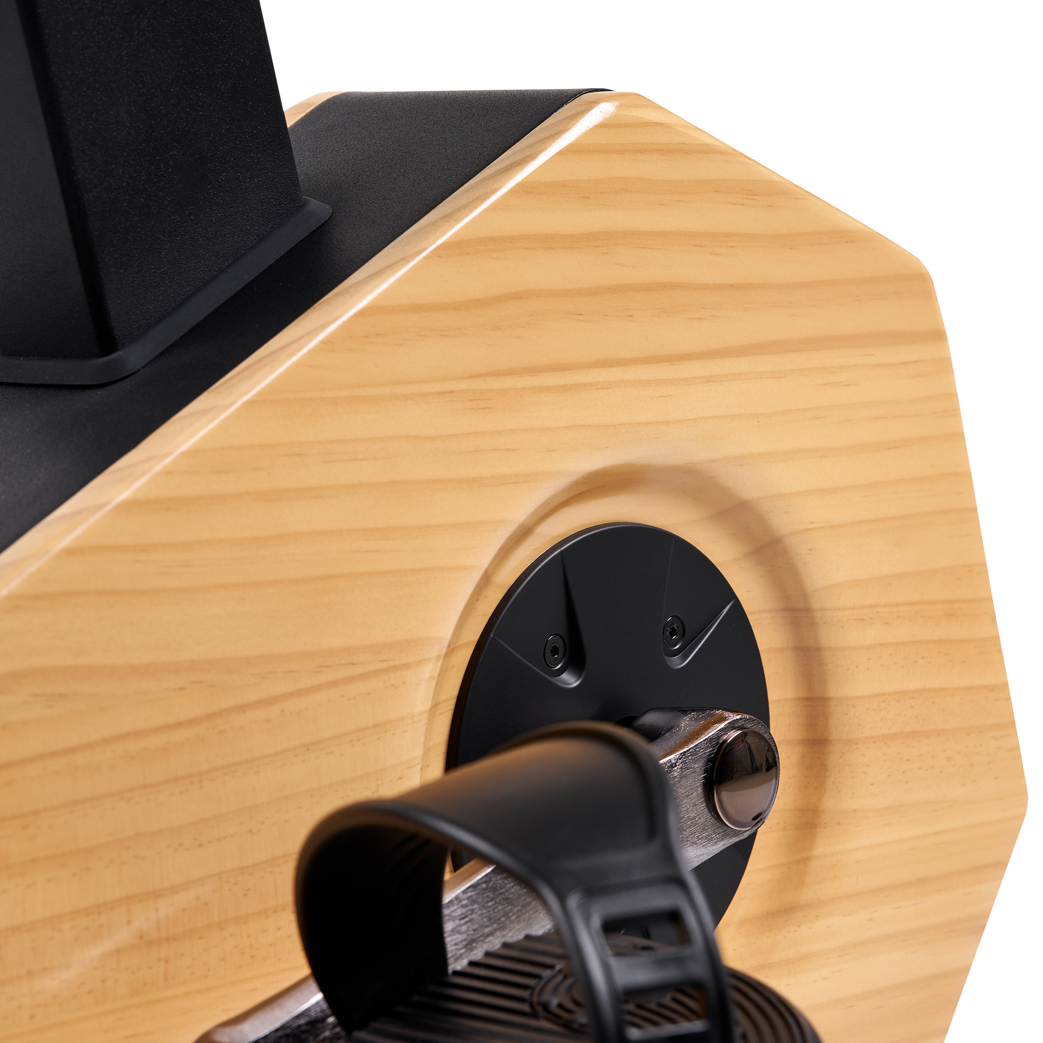Nahaufnahme des Pedals eines Heimtrainers. Schwarzer Riemen und Pedaldetail, Holzrahmen. Das Pedal ist silberfarben mit schwarzem Riemen.