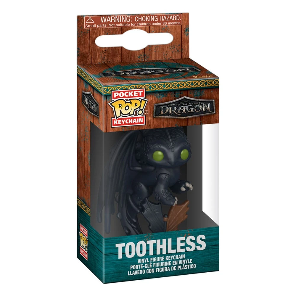 Llavero de Toothless en una caja. Figura de dragón negro con ojos verdes. La caja tiene texto y logotipos de 'Cómo entrenar a tu dragón'.