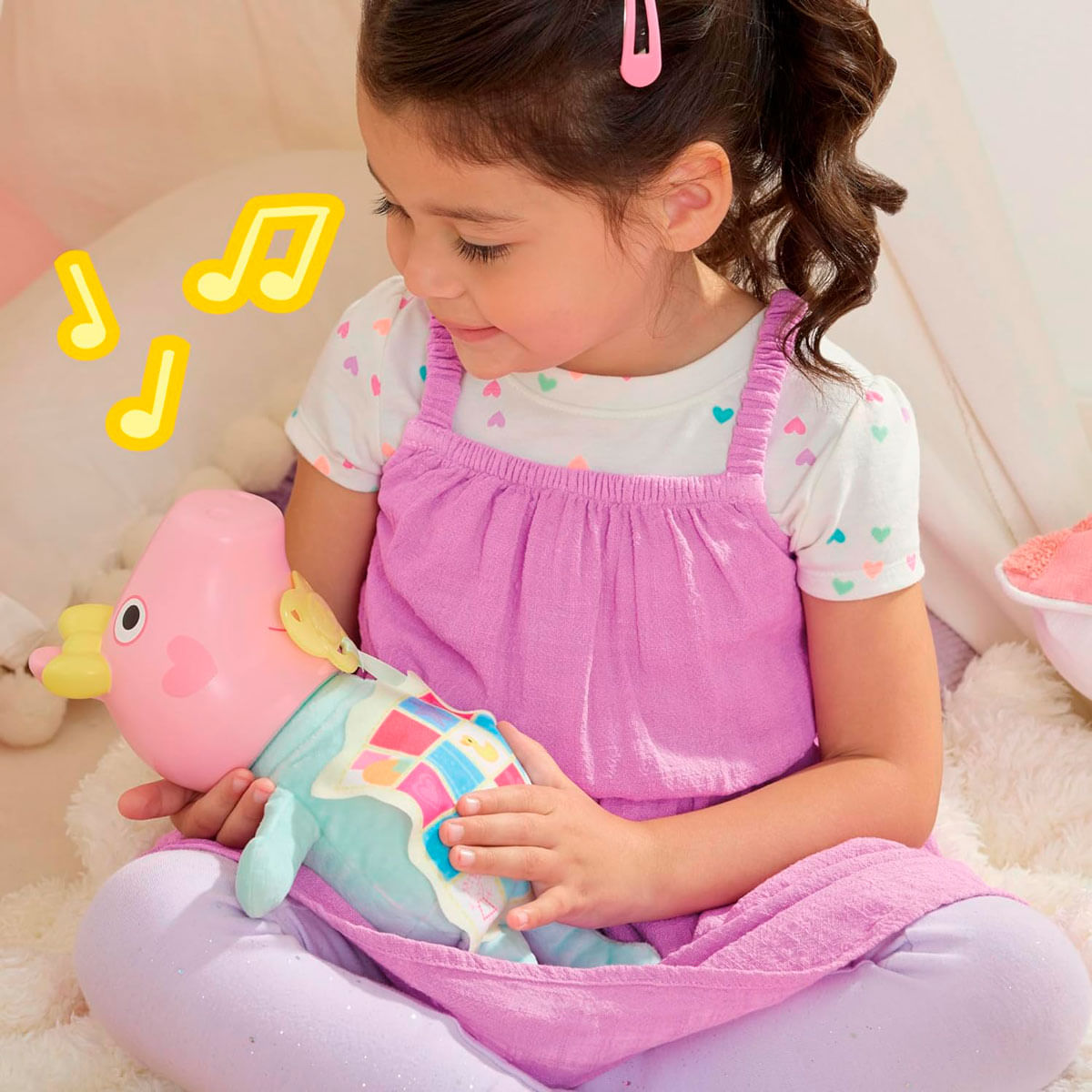 Ein Mädchen in rosa Kleid hält ein rosa Spielzeug. Das Spielzeug hat Flügel und Herzform. Noten um das Mädchen herum.